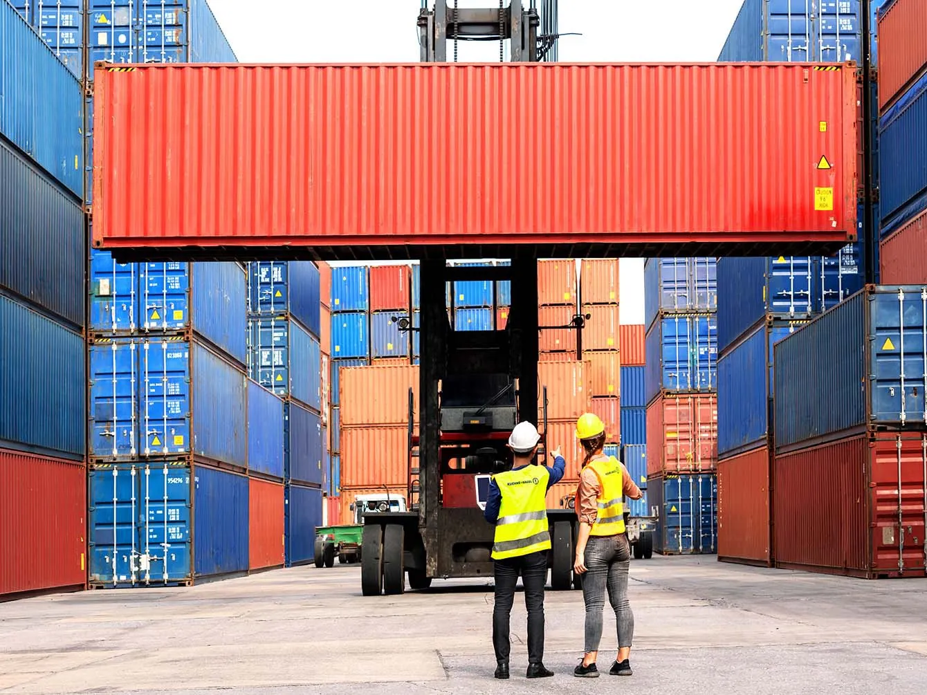 Two workers talking and looking at the container