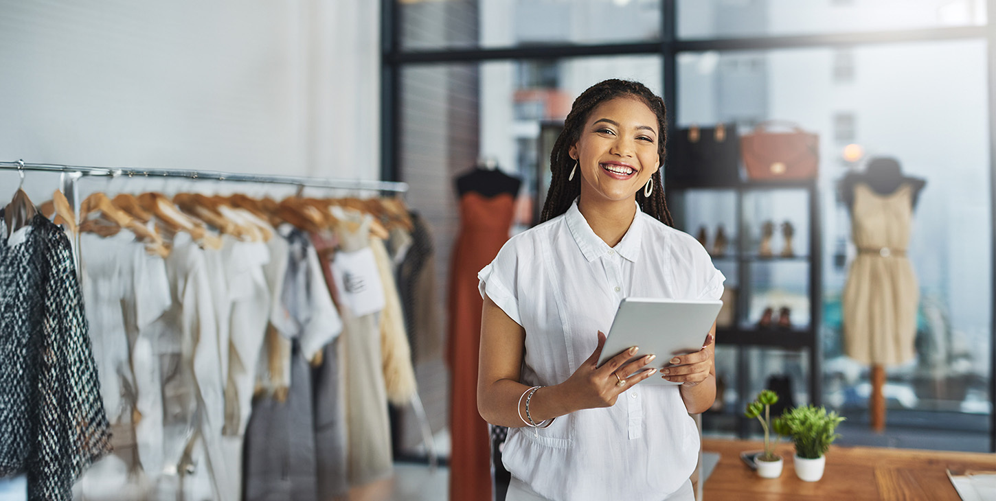 Smiling employee in a store holding a tablet