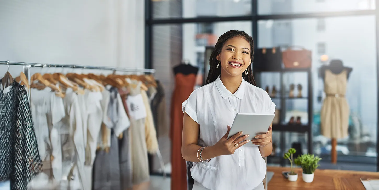 Smiling employee in a store holding a tablet