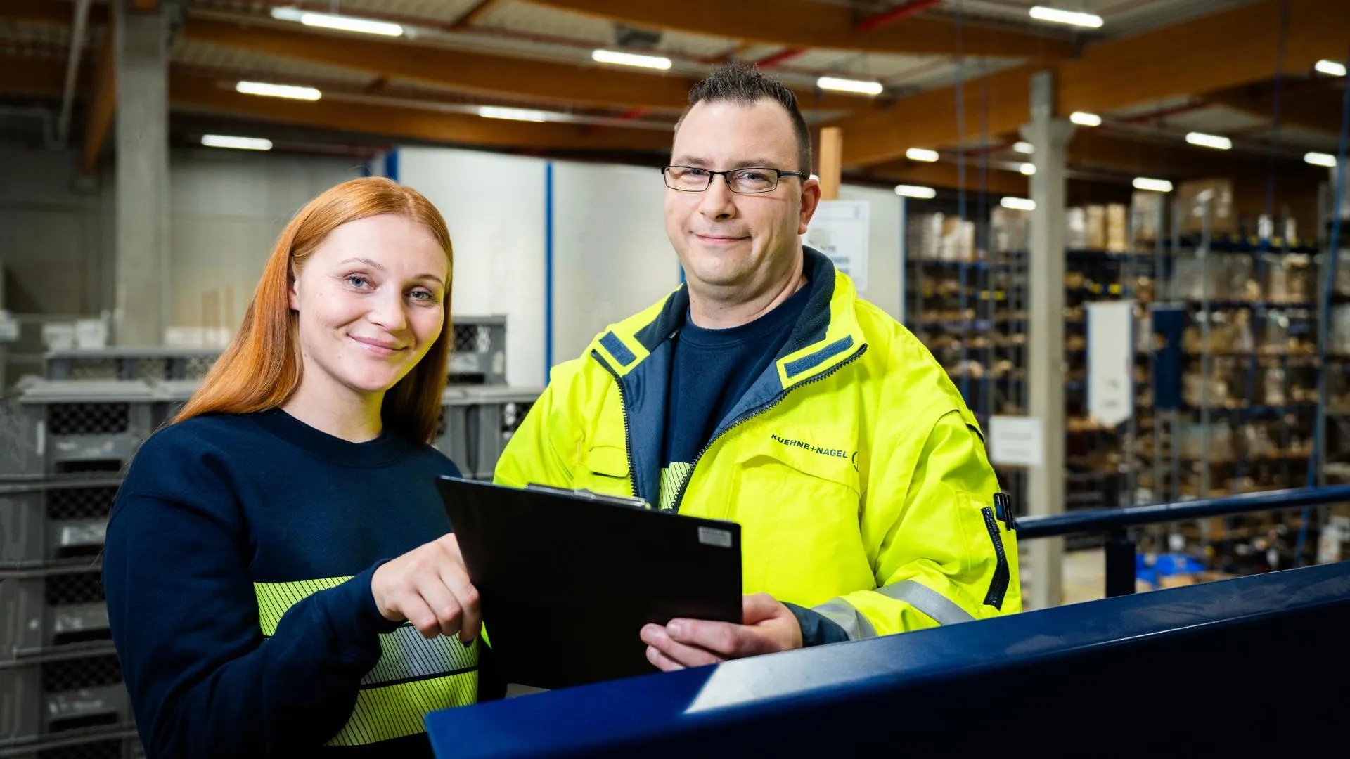 Workers beihnd a tablet in the warehouse