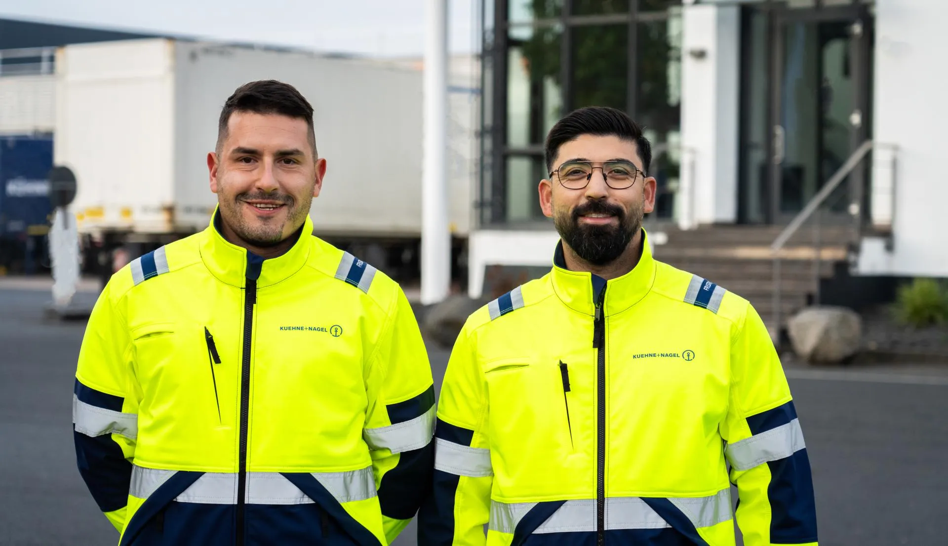Kuehne+Nagel colleagues standing next to each other smiling into the camera.