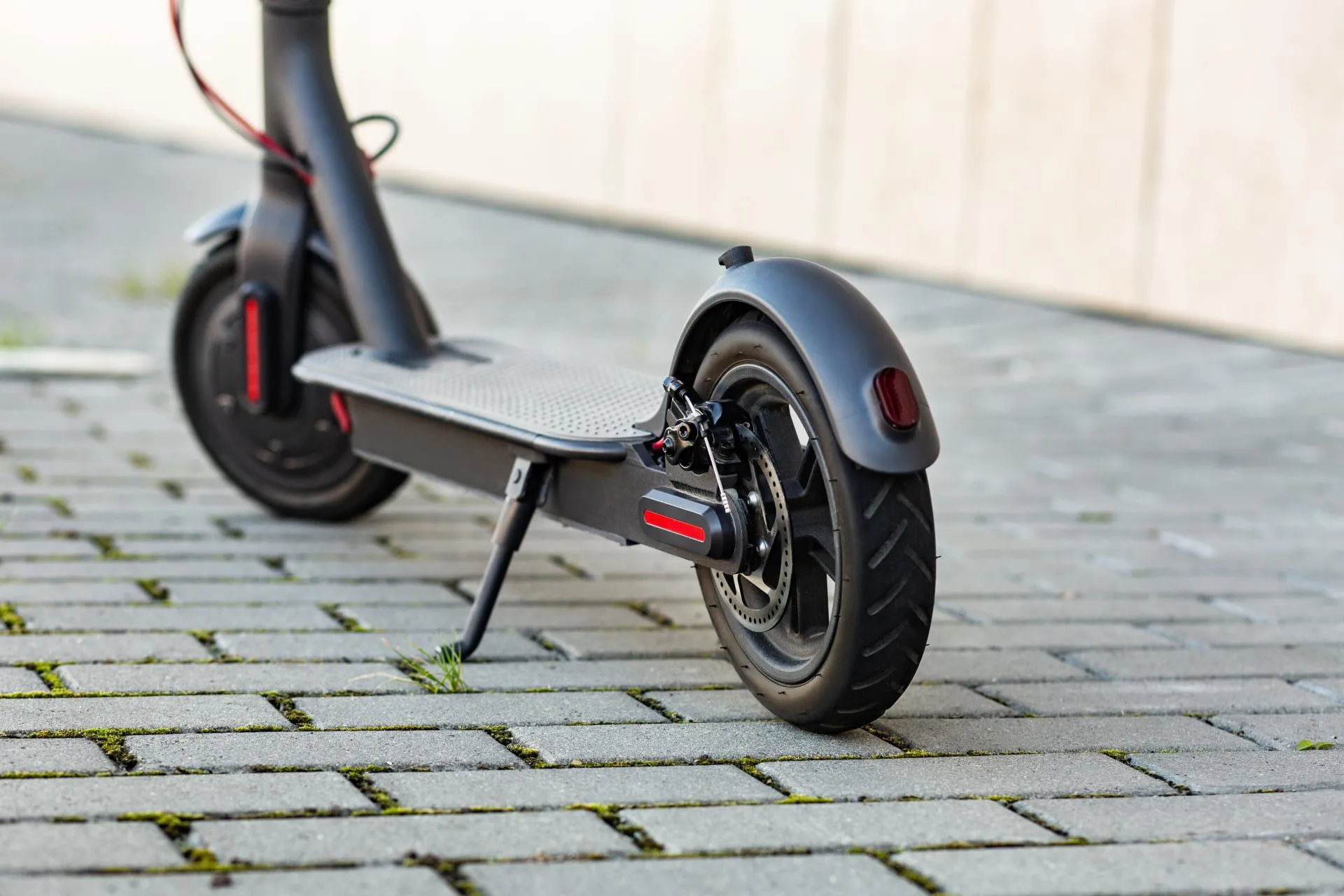 Close-up view of an e-scooter parked on a sidewalk.