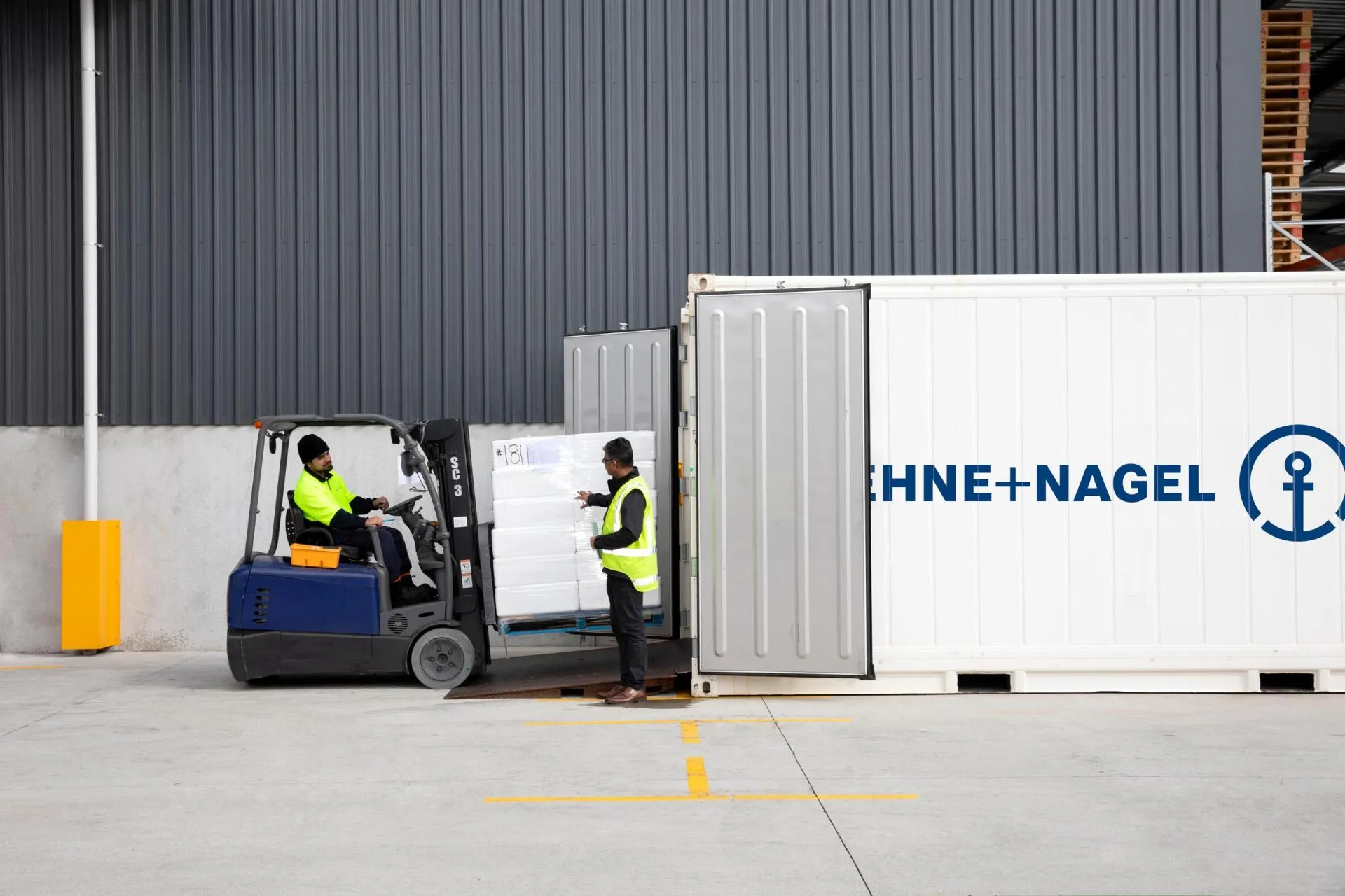 Workers loading packages into truck container