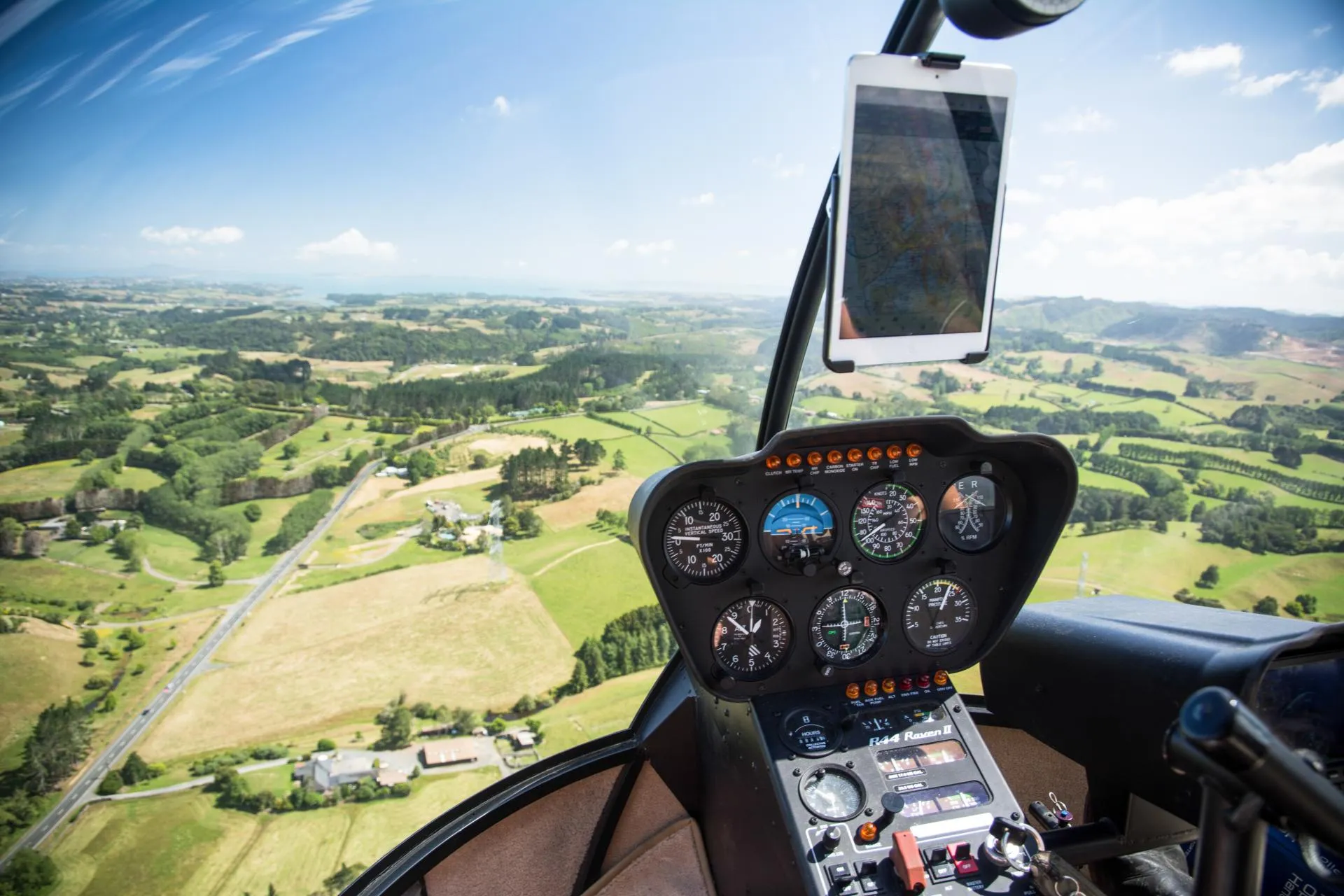 Helicopter cockpit with view of lush green landscape through the window