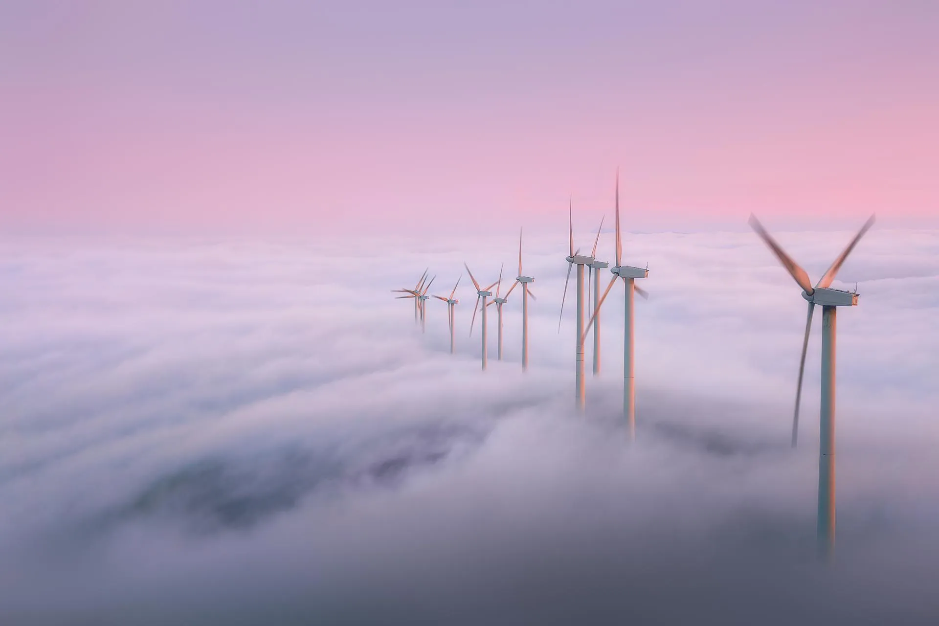 Wind turbine wheels above the clouds at sunrise