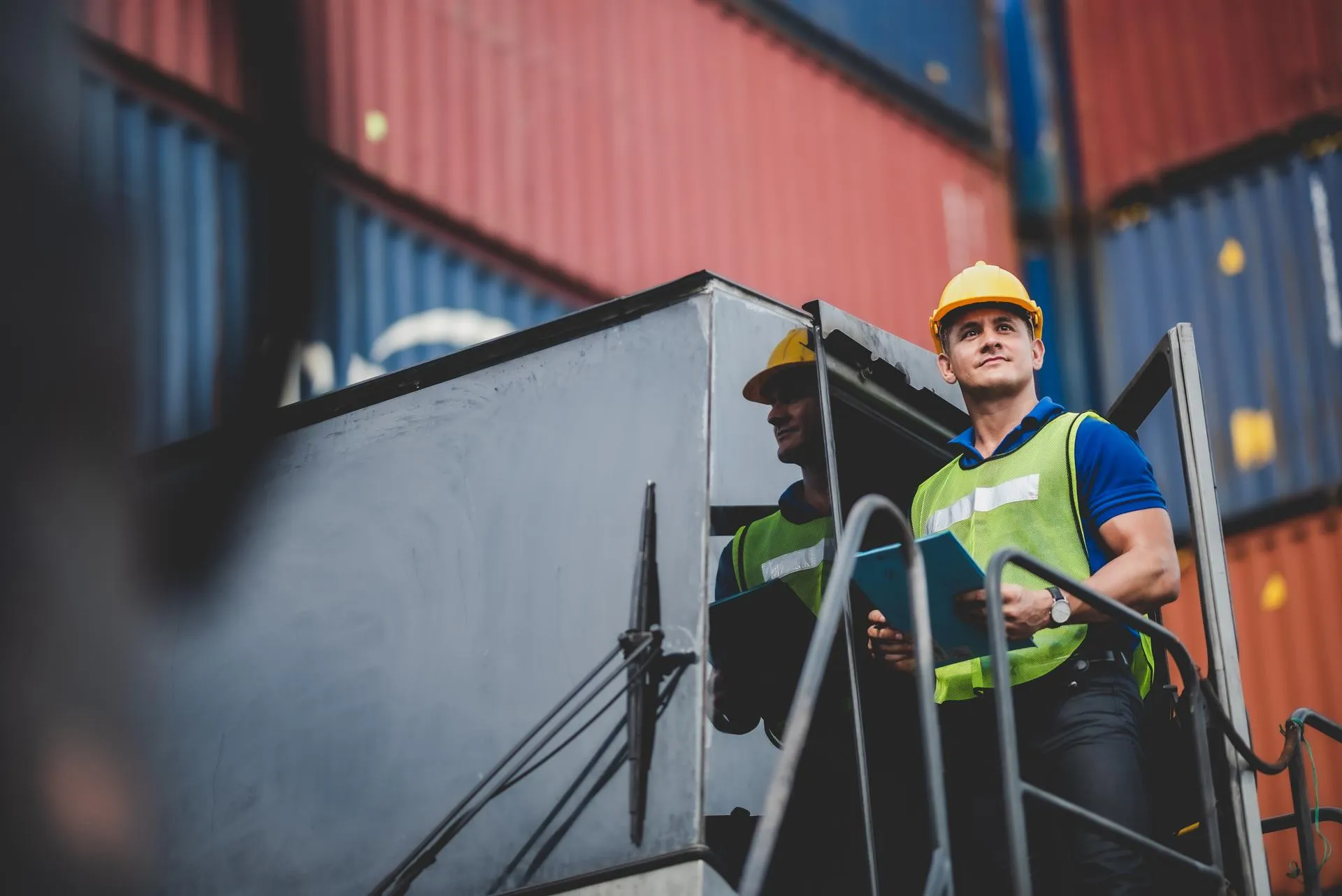 Employee standing with a board in front of shipping containers