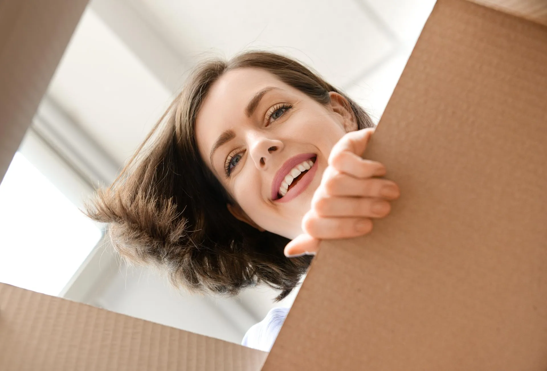 A joyful moment as someone opens a box with a smile