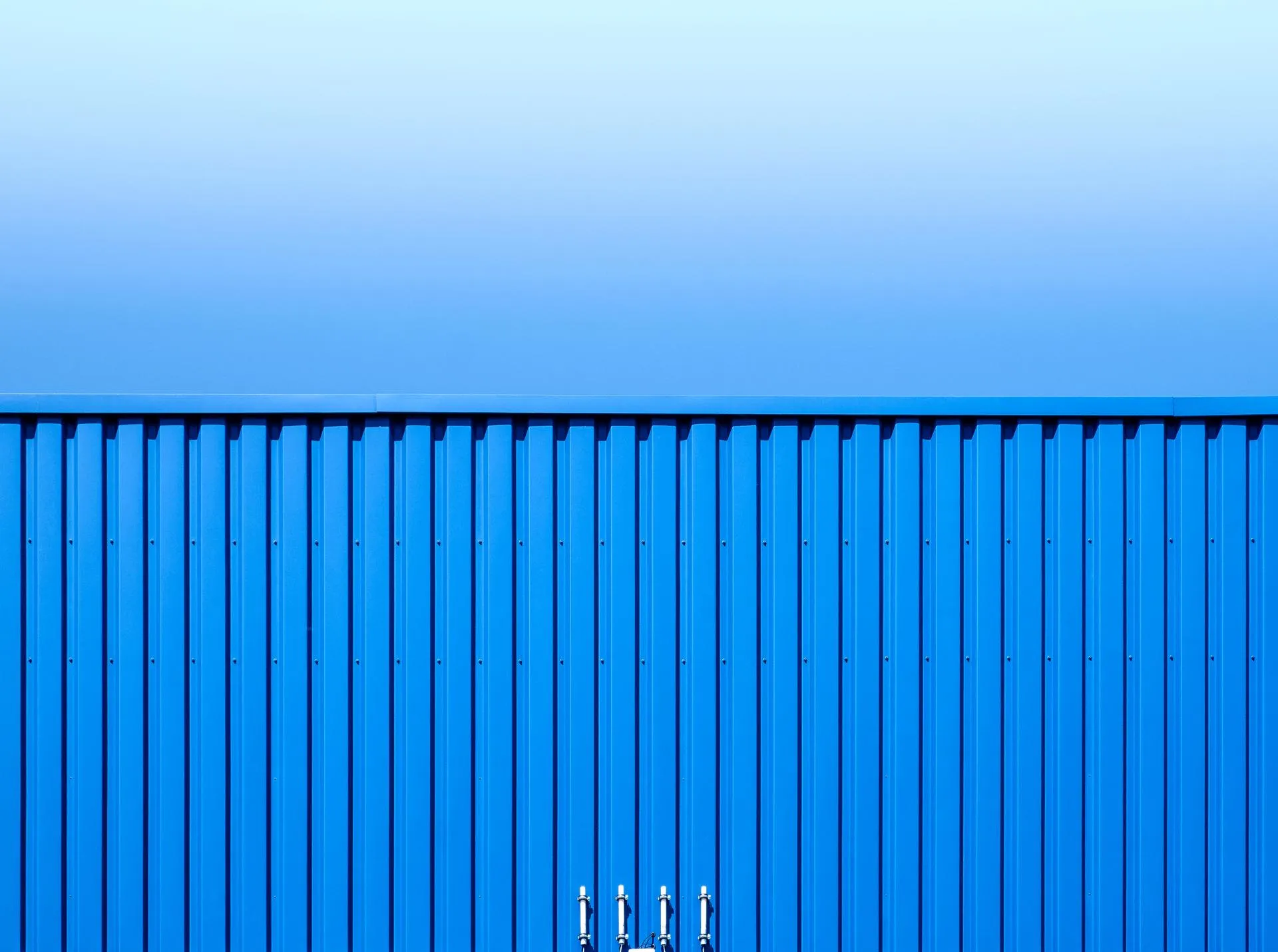 A blue container against a blue sky.