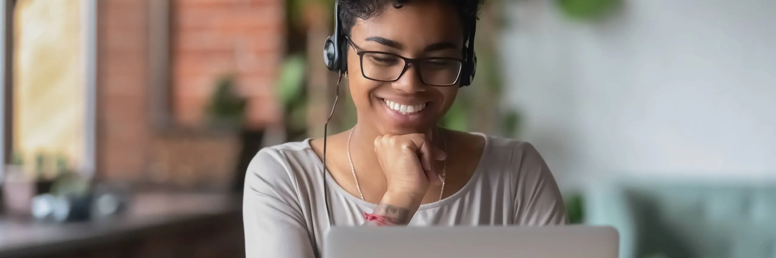 Woman with a headset sitting in front of a laptop