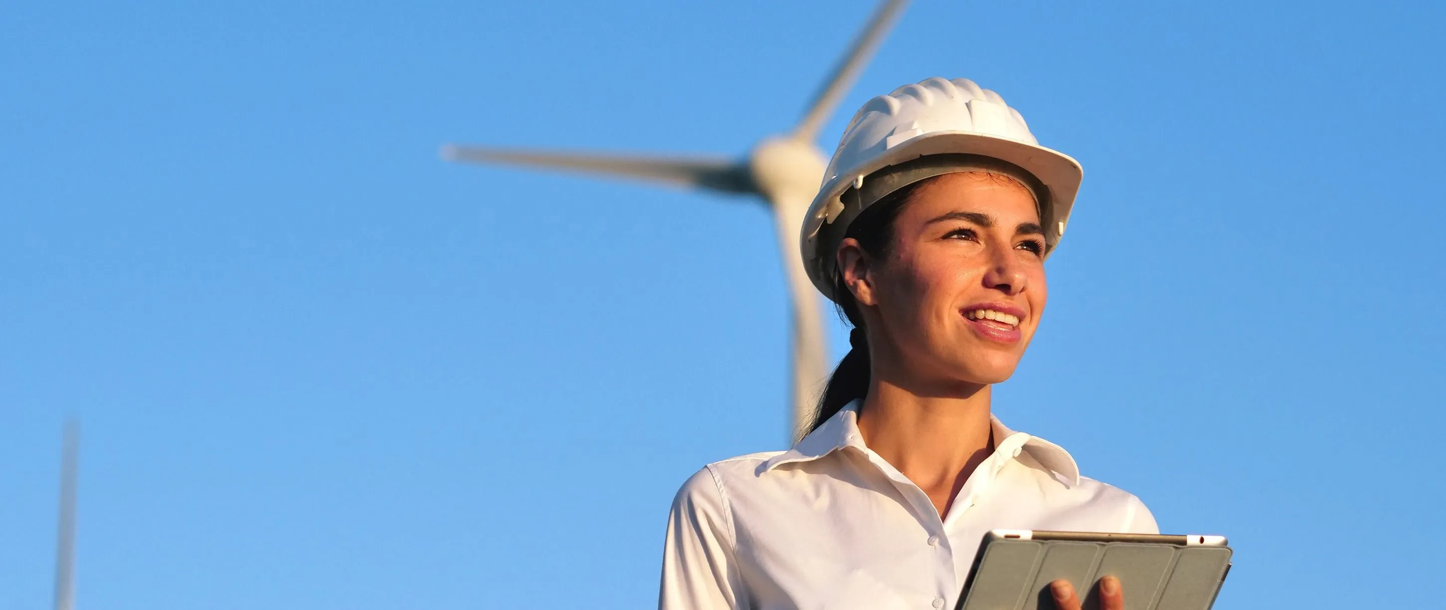Woman standing in front of a wind turbine