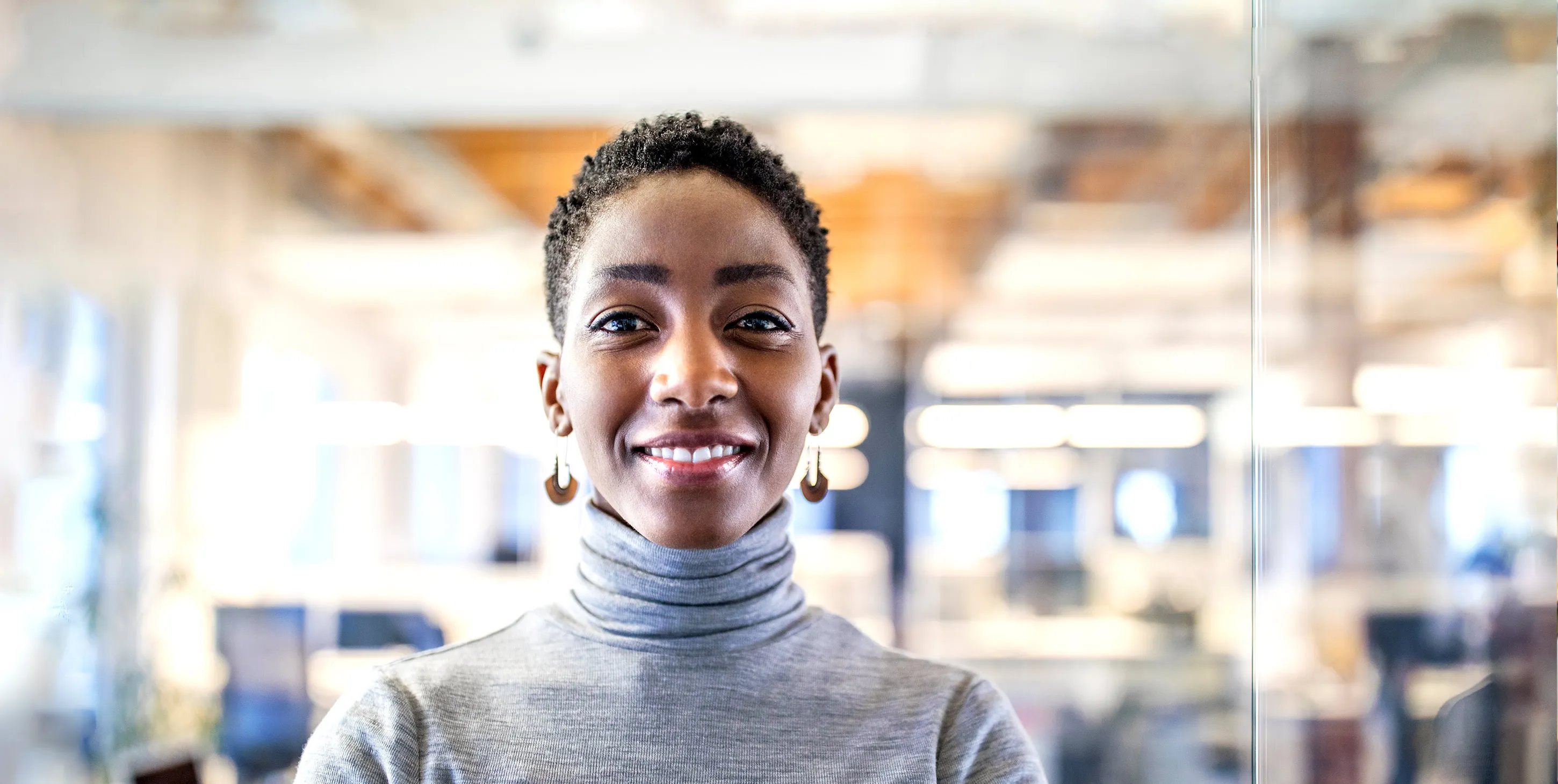 A coloured woman in an office smiling at you