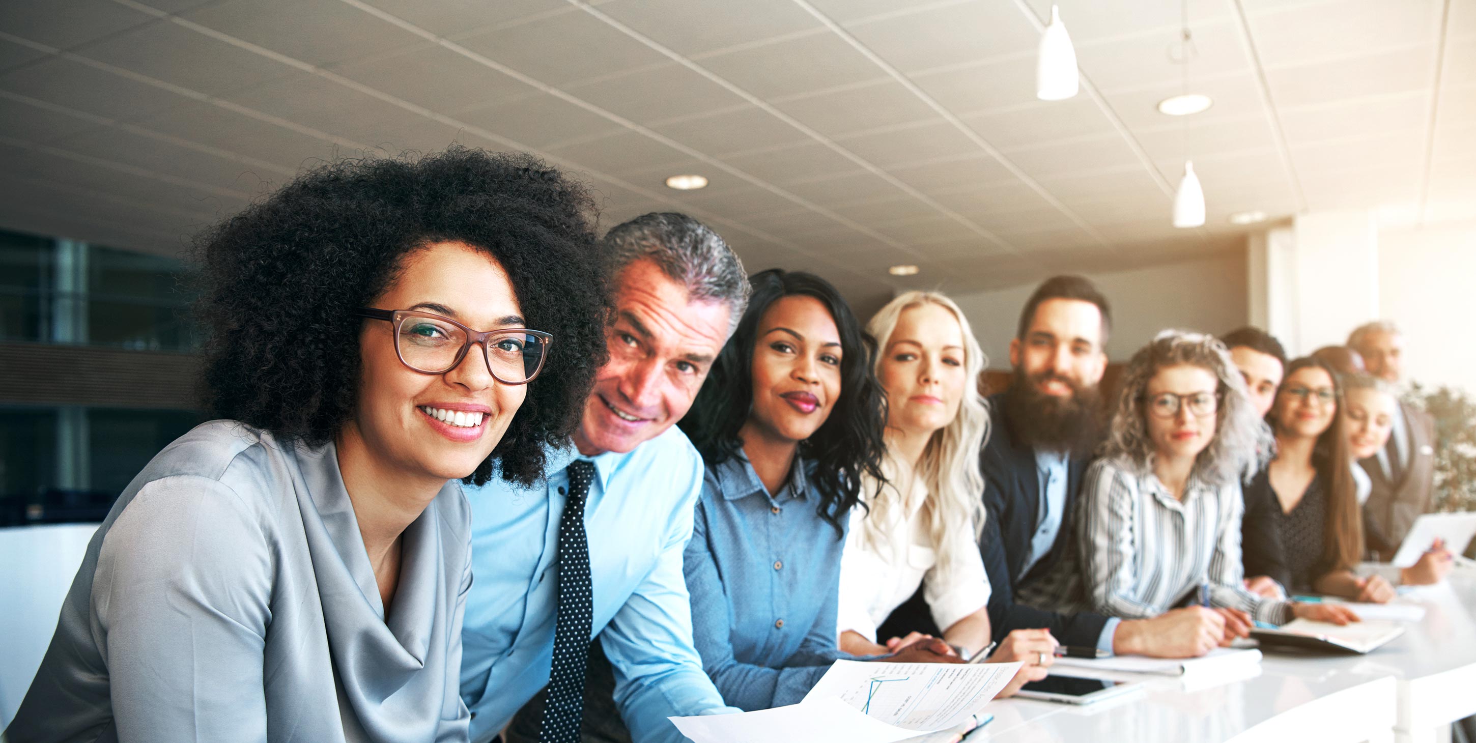Um grupo de pessoas em trajes profissionais sentadas à mesa durante uma reunião ou conferência