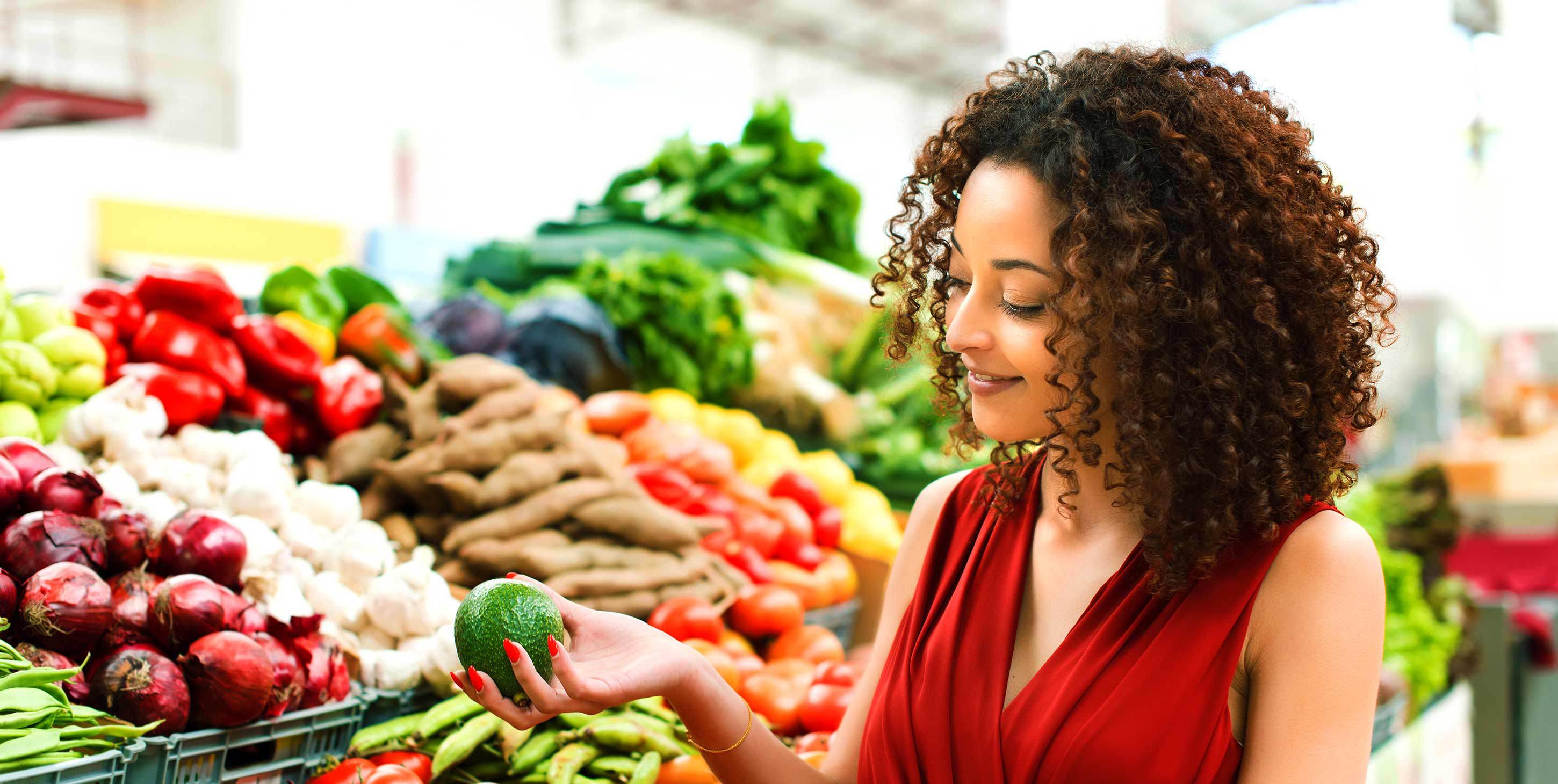 A woman is happily examining fresh produce