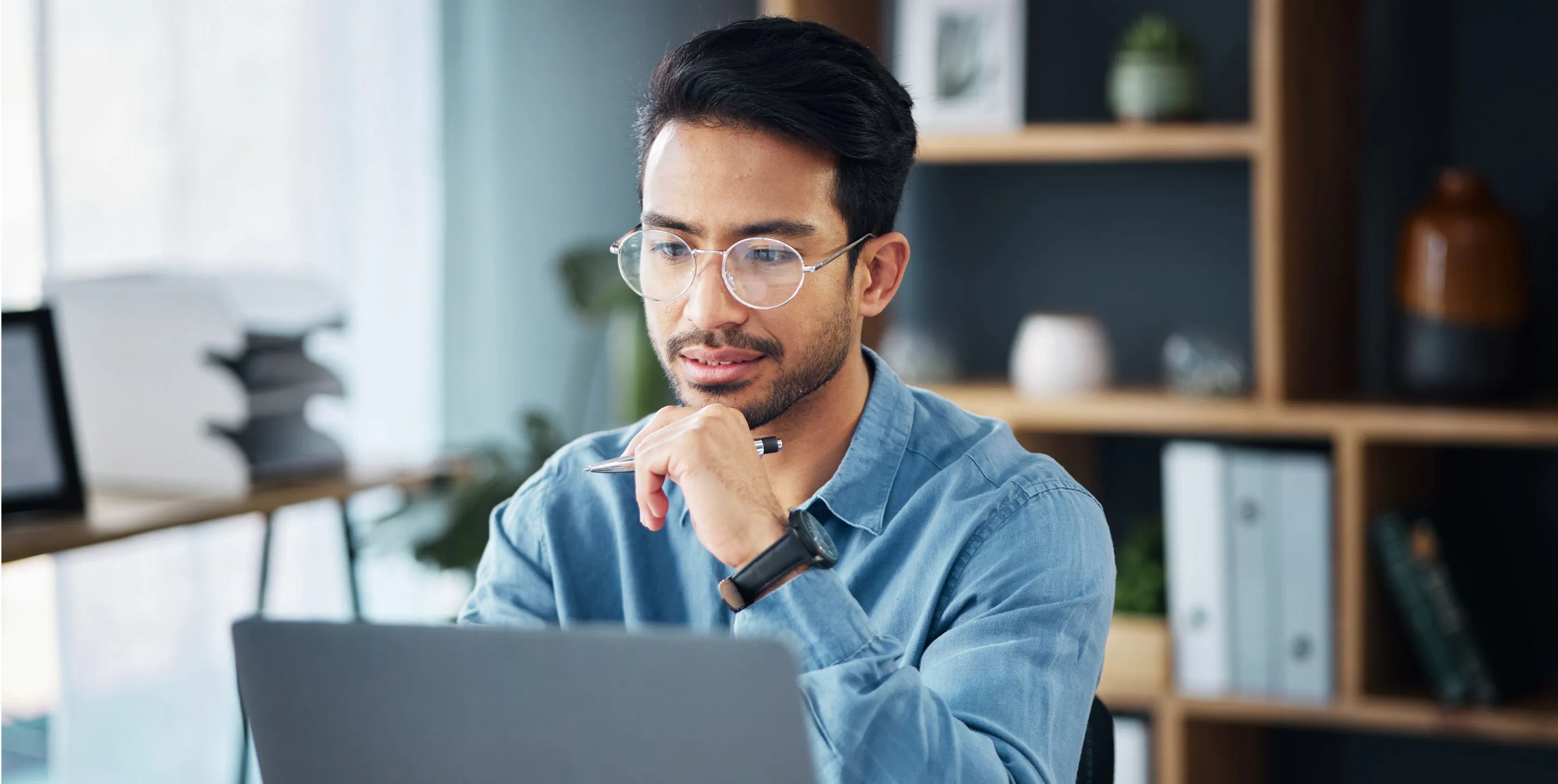 Businessman thinking in front of laptop