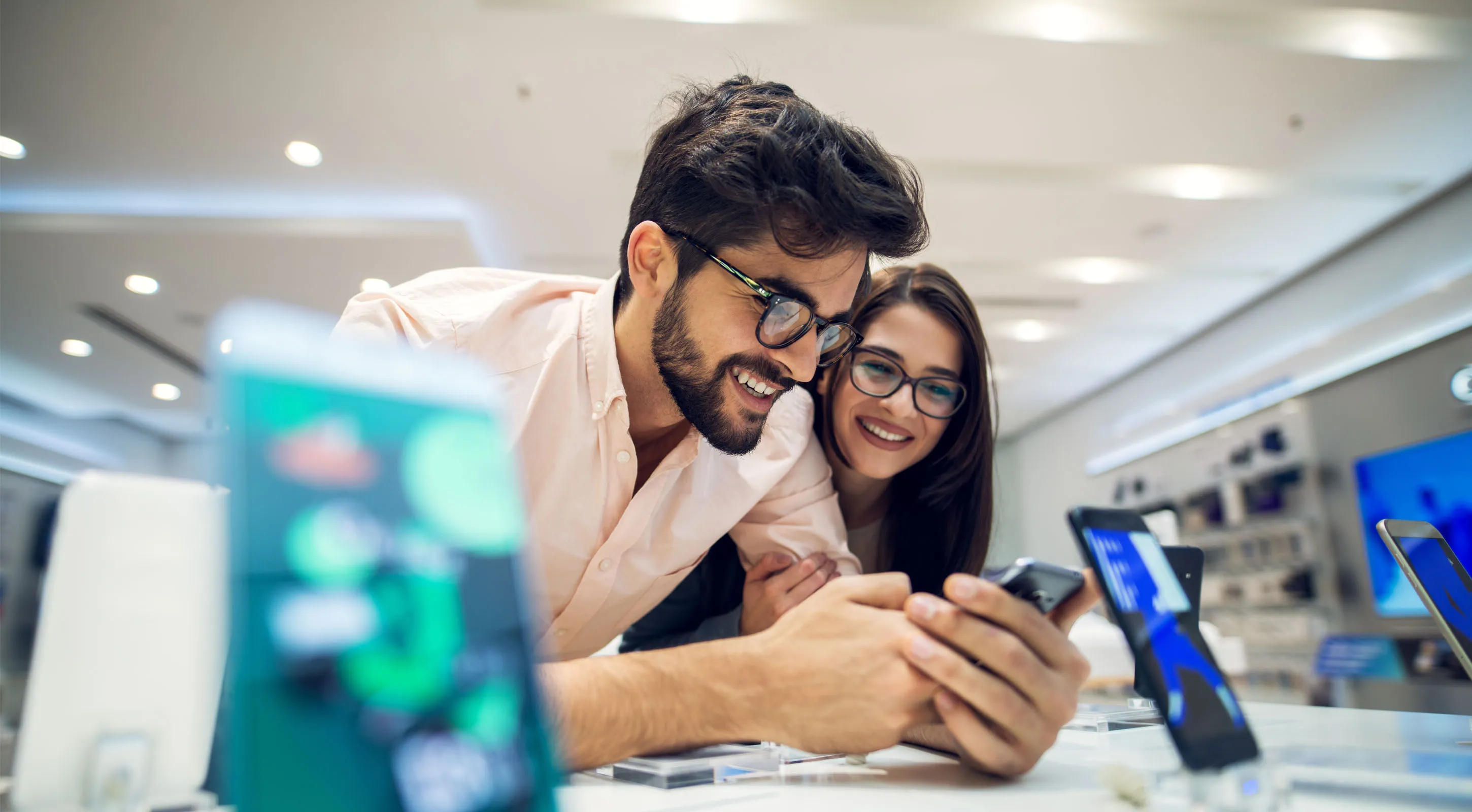 Man and woman in a store reviewing new phones