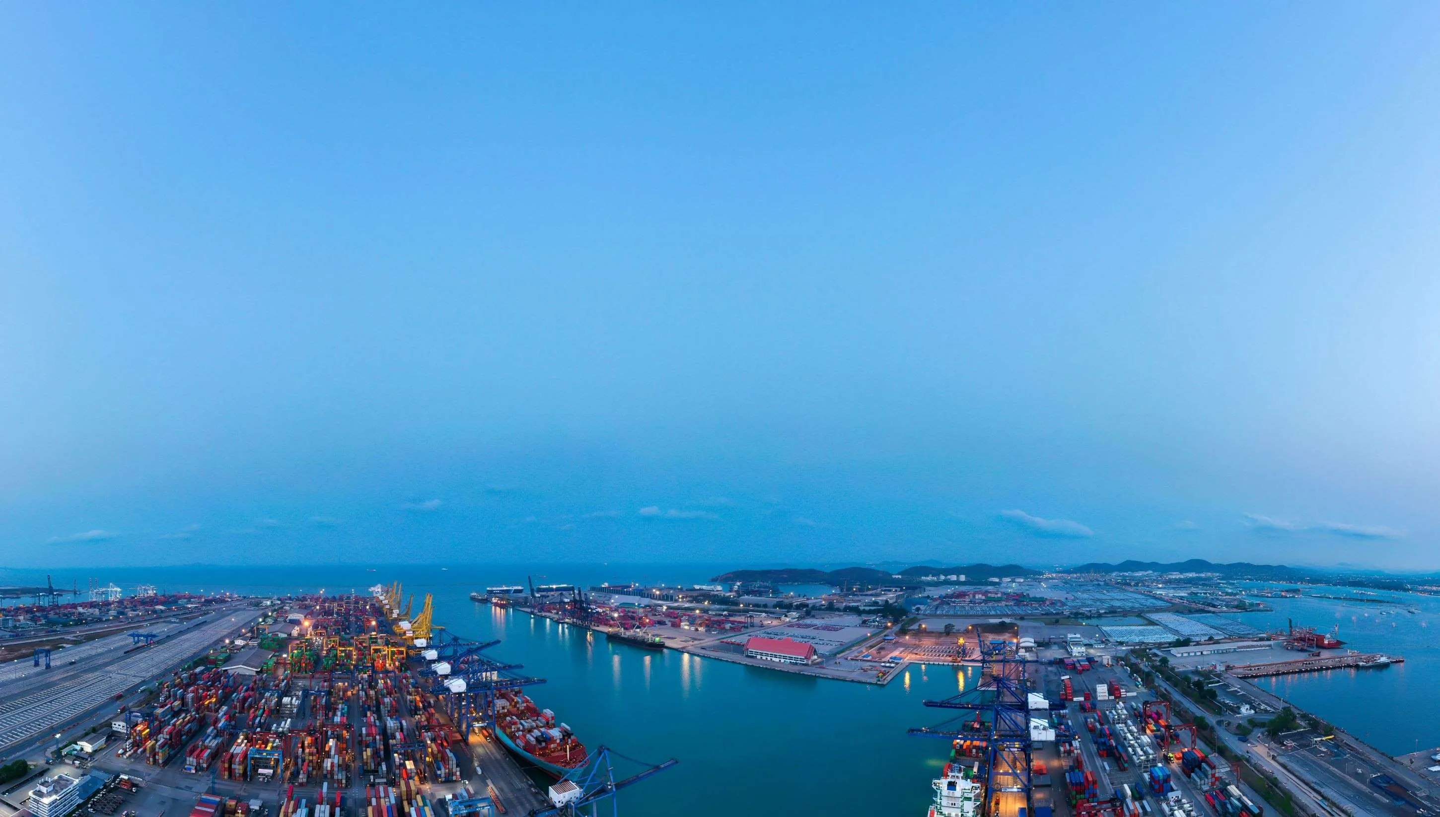 Harbour view at blue hour with containers, vessels and horizon