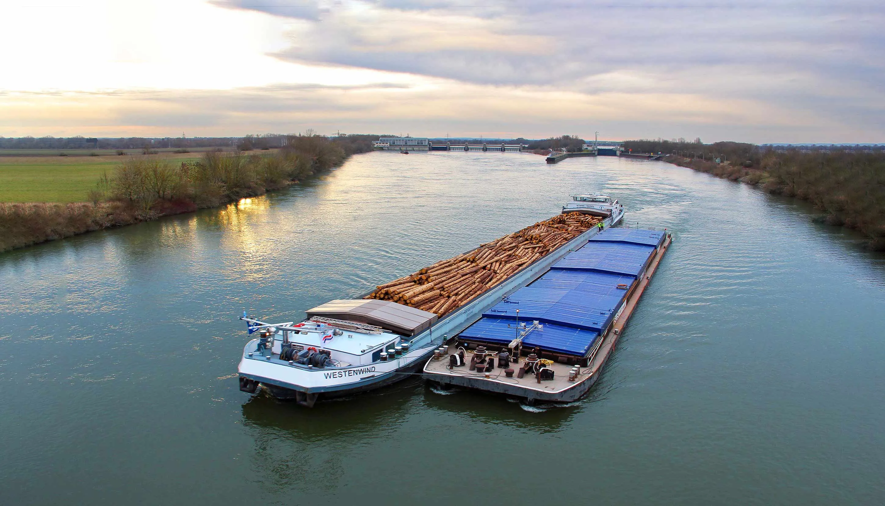 2 boats shipping cargo thru a river with the river shipping service