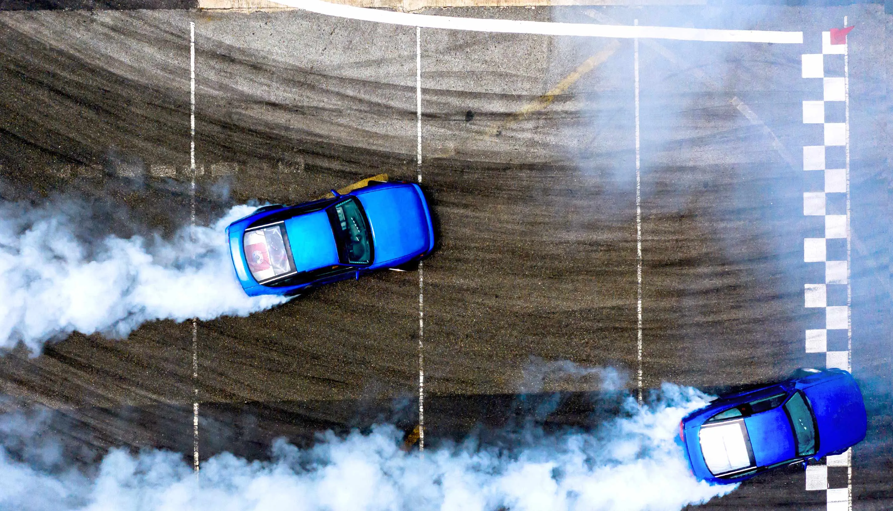 Bird's eye view on two blue cars drifting on the track