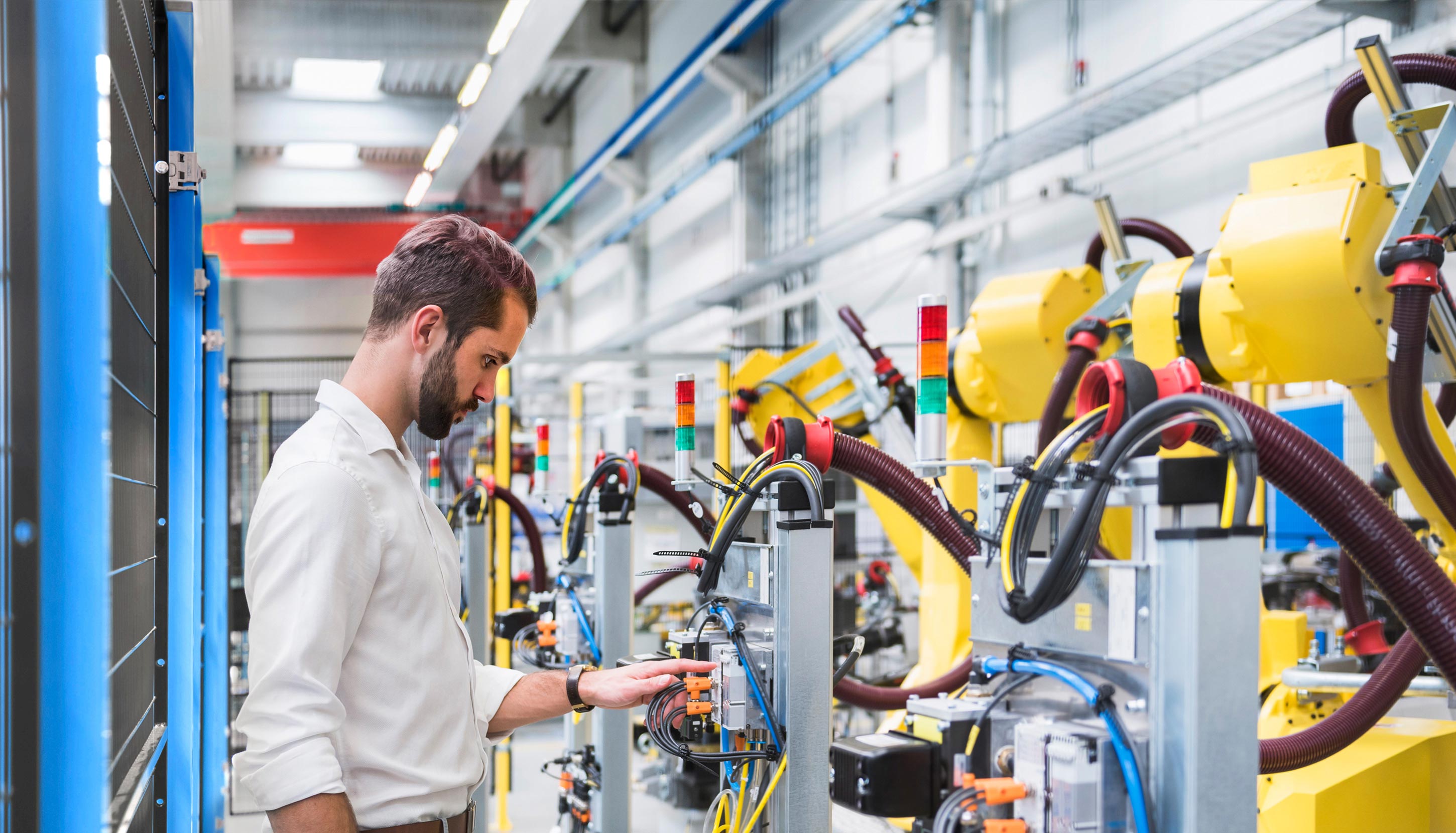 Technician managing robotic systems in industrial logistics facility