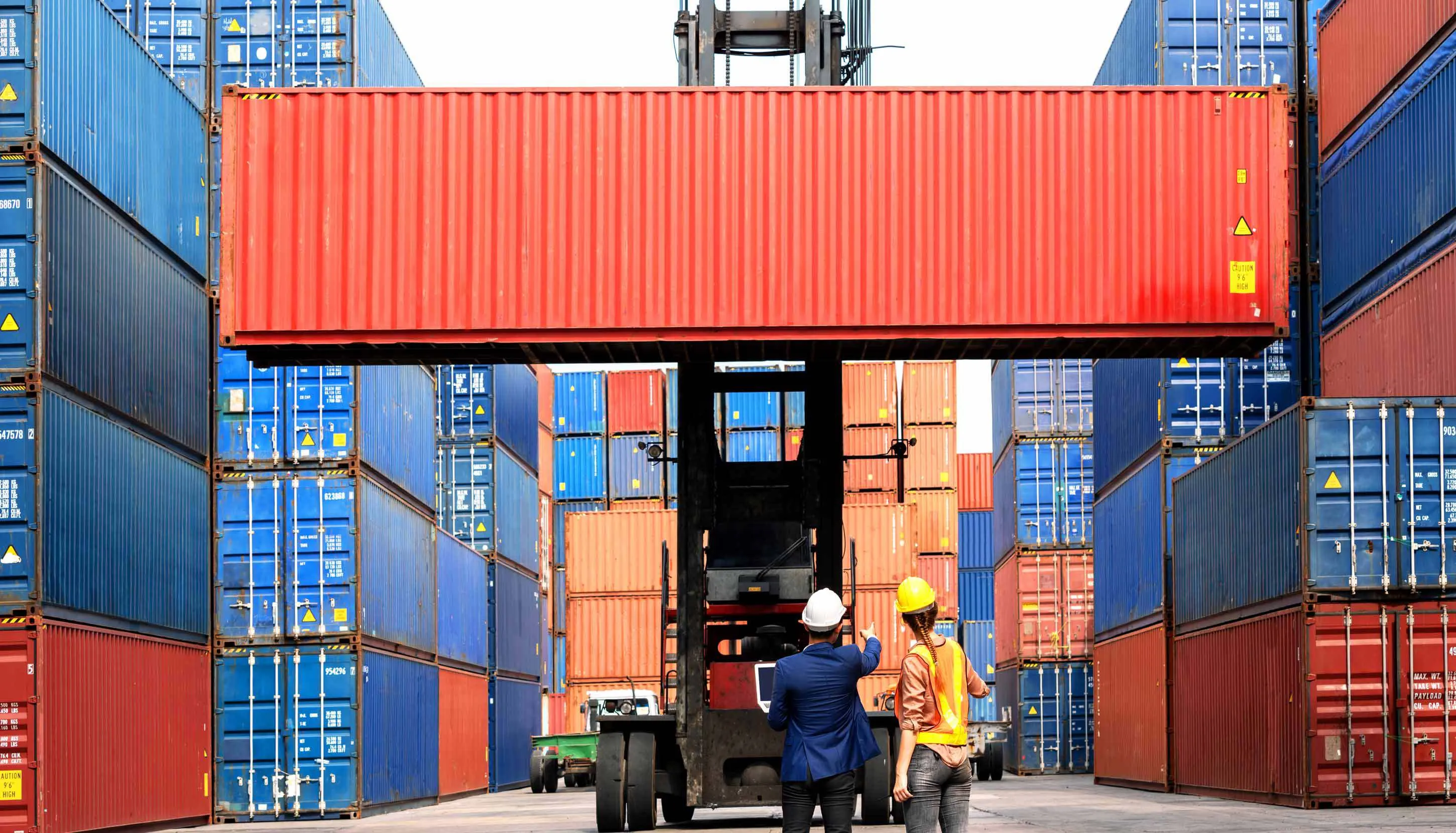 Container being transported in a harbour with two people surveying