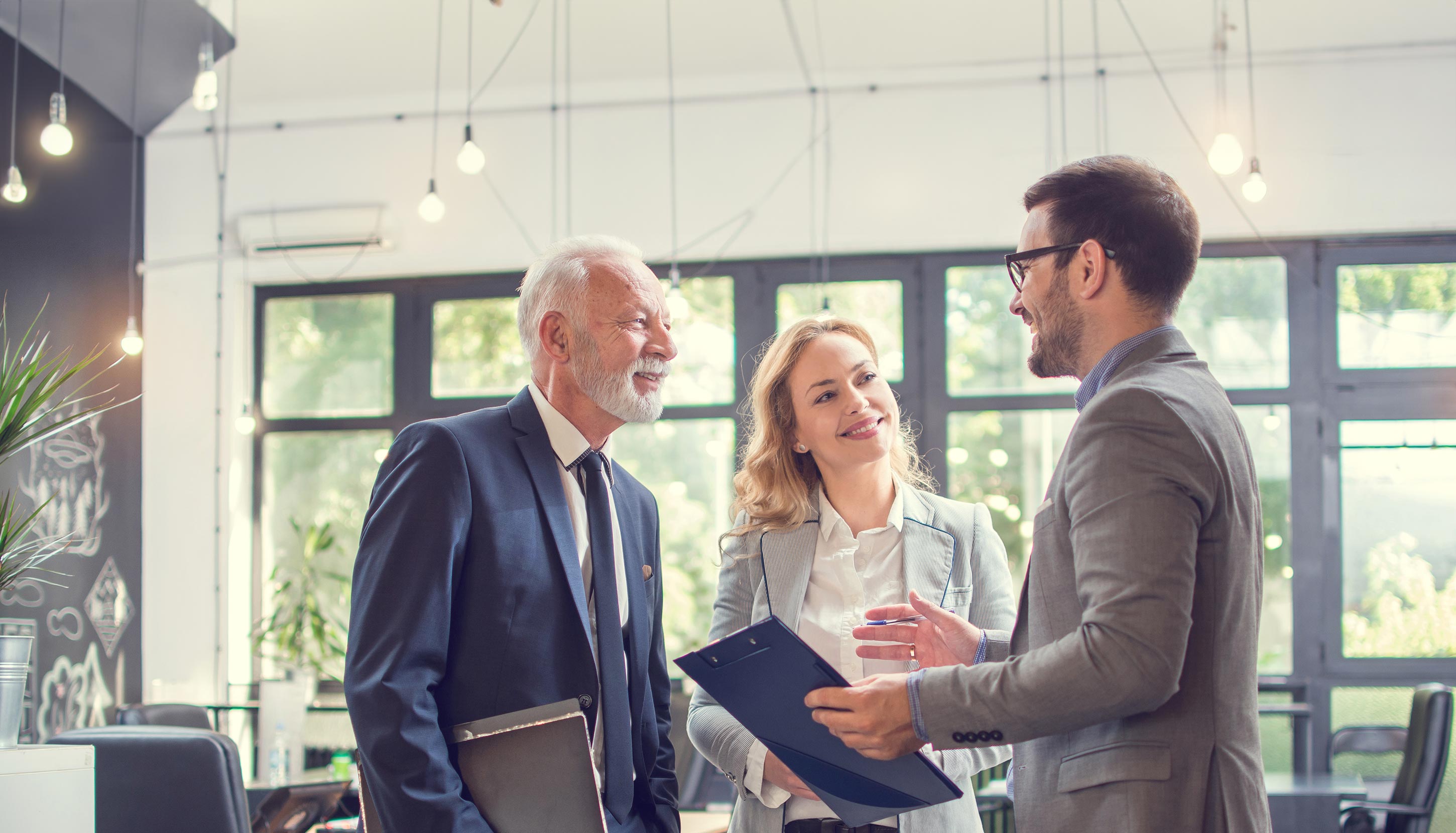 A trio of custom experts are standing in an office.