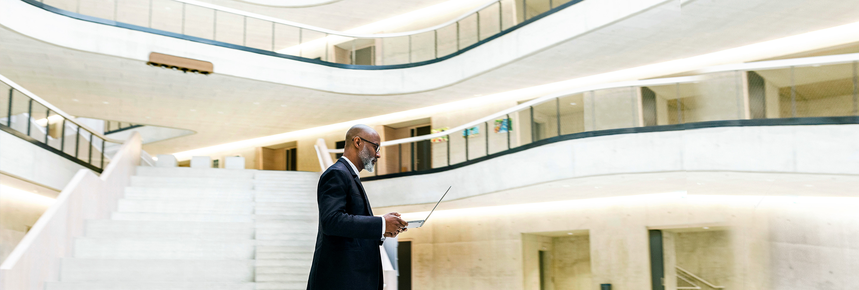 Businessman walking looking at laptop