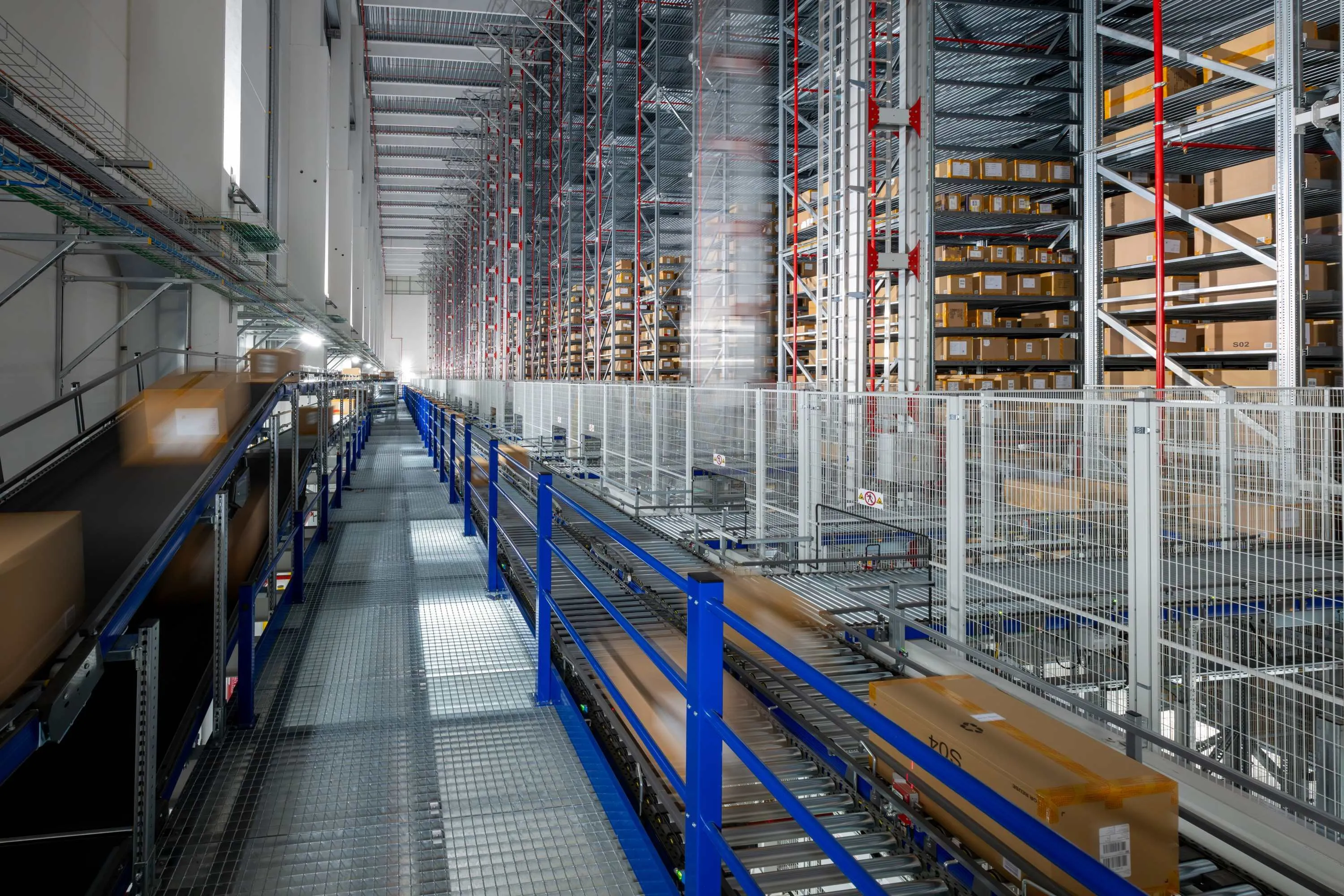 Automated warehouse with conveyor belts and stacked shelves of packages.