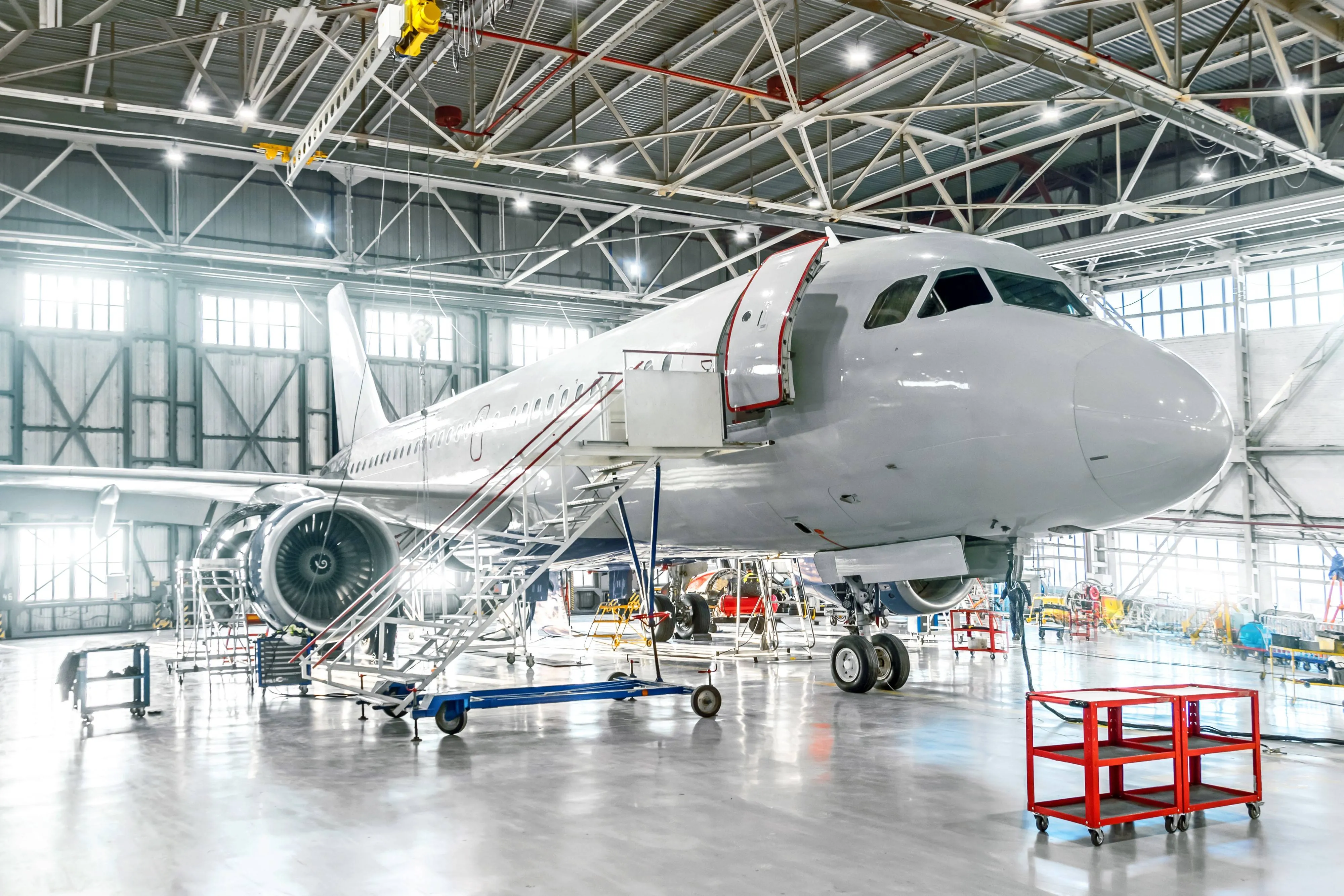Aircraft under maintenance, checking mechanical systems for flight operations. Plane in the hangar.