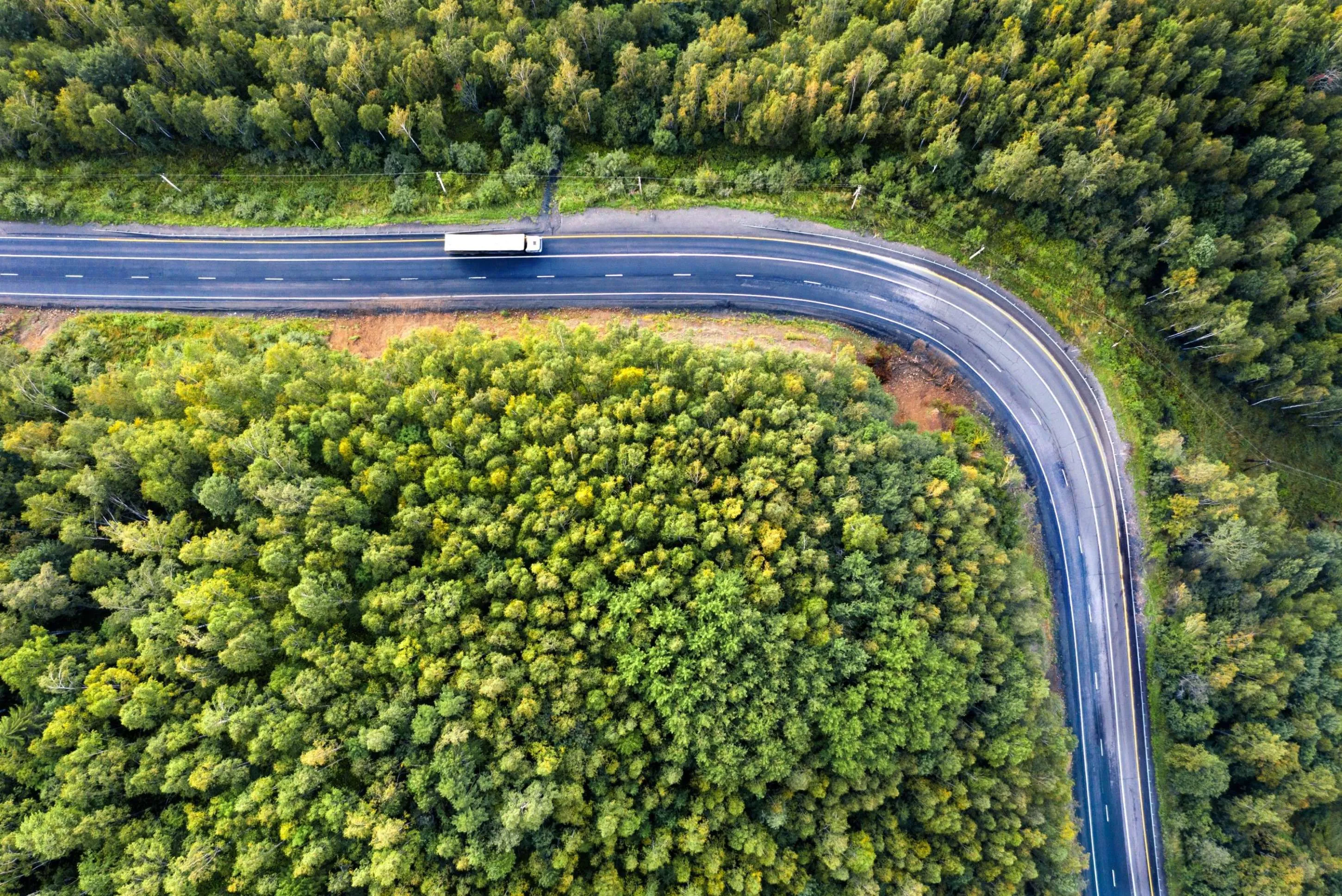 Semi truck with cargo trailer on the highway. Transportation and natural scenery background with copy space.