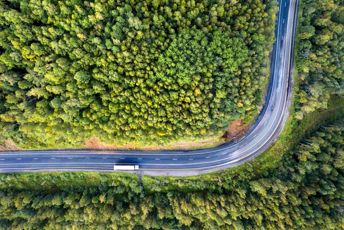 Semi truck with cargo trailer on the highway. Transportation and natural scenery background with copy space.