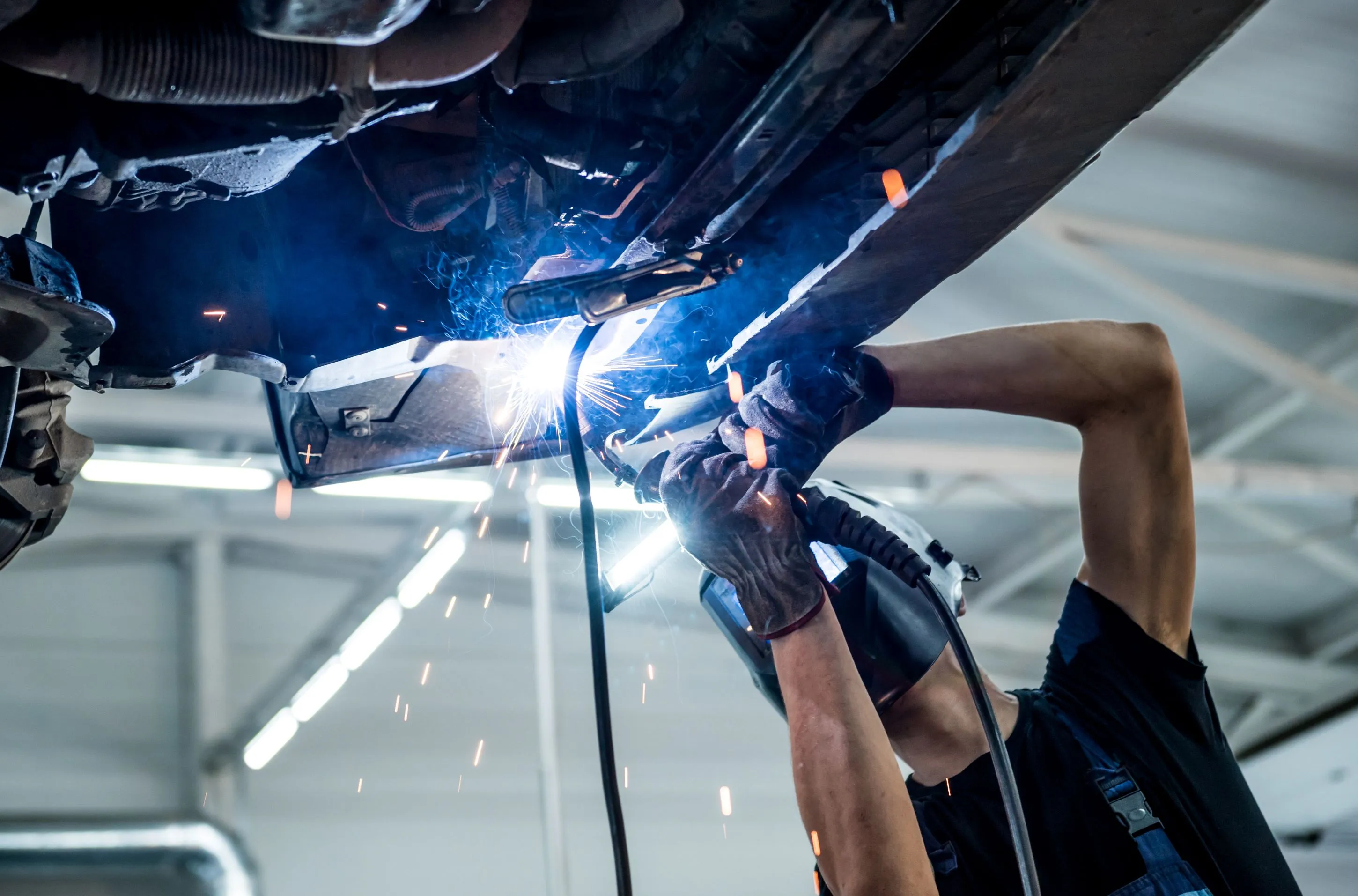 Mechanic hard at work under the hood in a modern garage