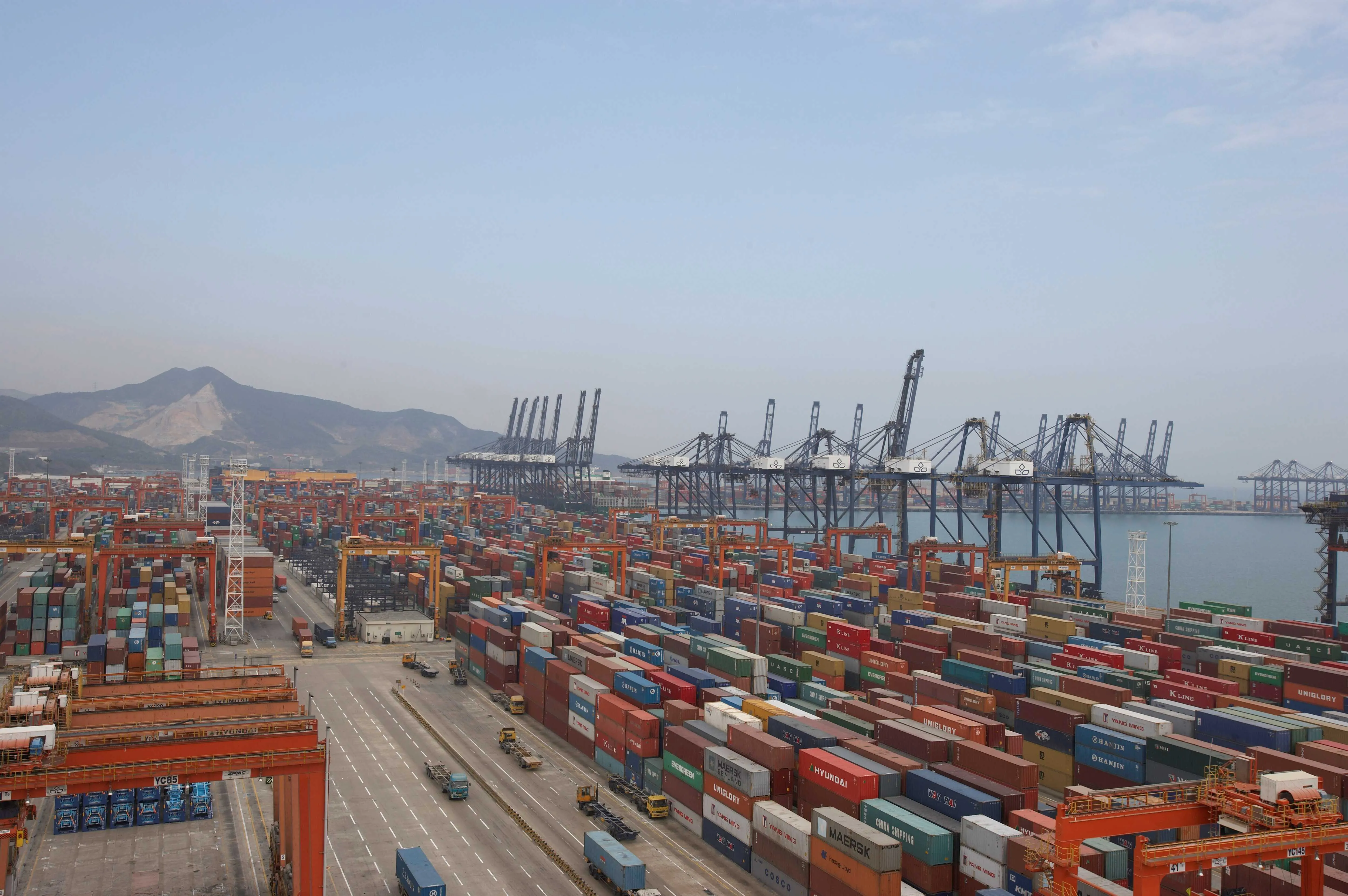 Container terminal with stacked shipping containers, cargo cranes, and transport infrastructure supporting multimodal logistics operations and international supply chains.