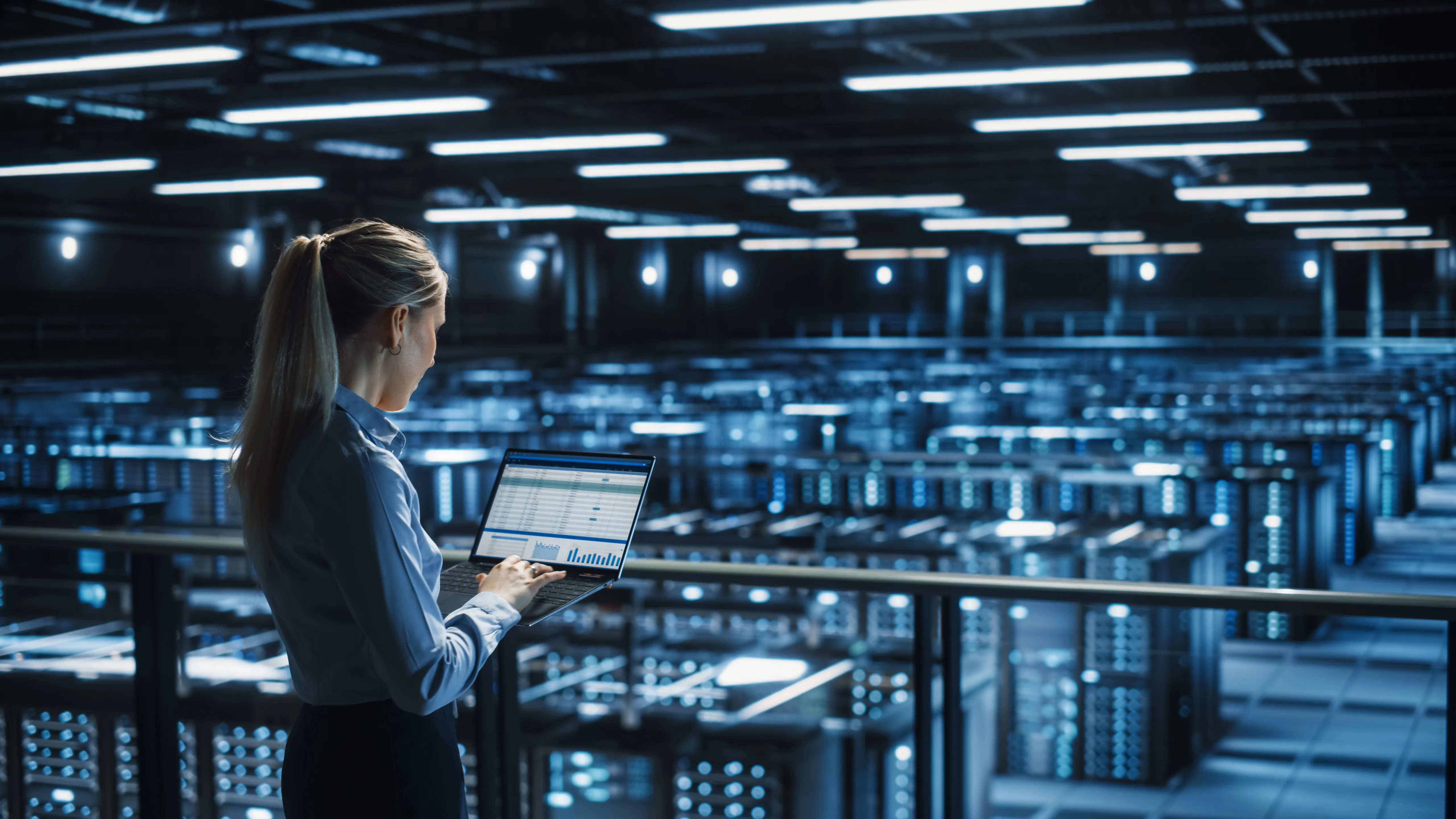 Data center female it specialist uses laptop computer. Cloud computing server farm with it engineer monitoring statistic, maintenance control. Information technology of fintech, e-business.