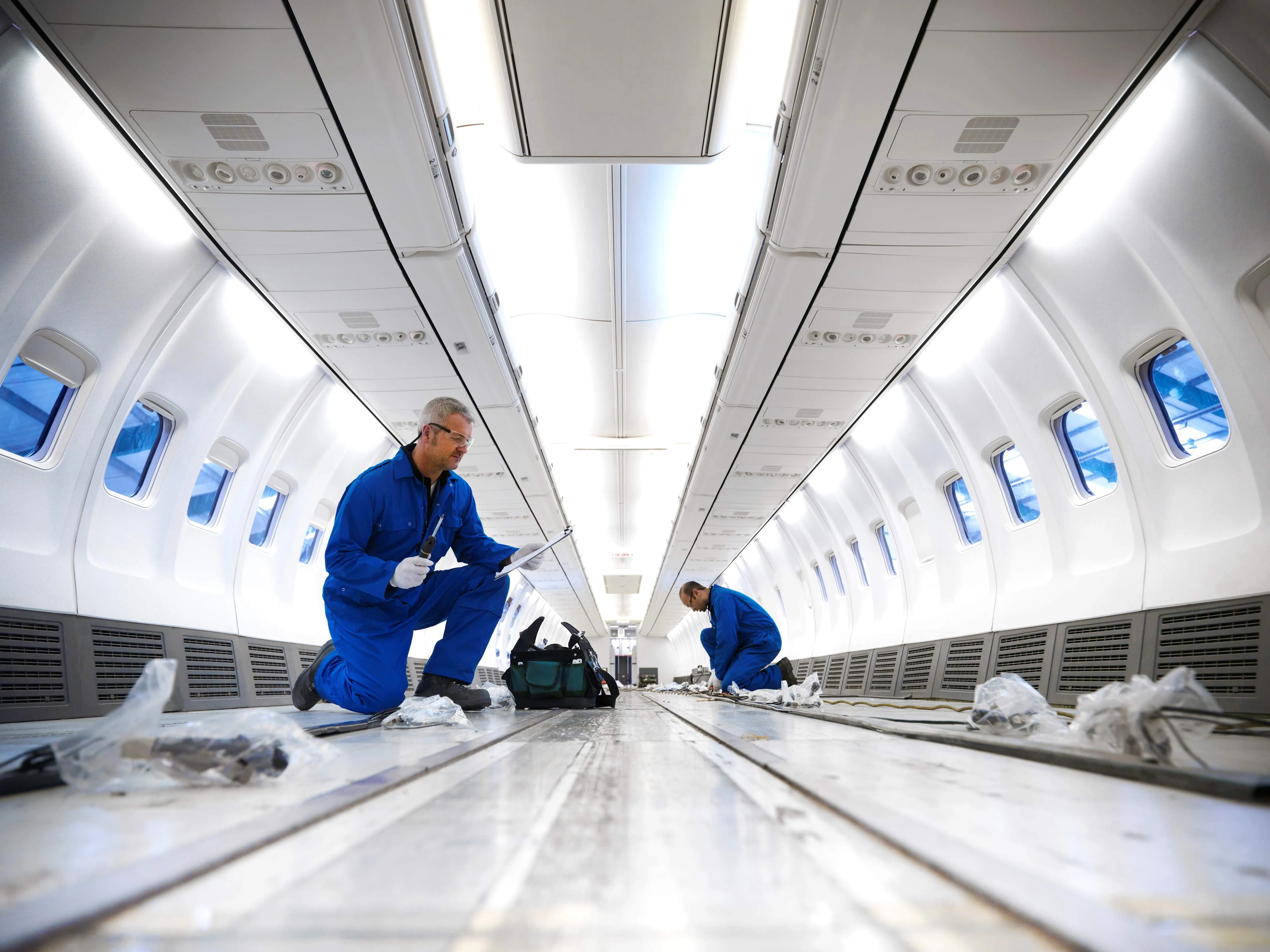 Aircraft engineers working on interior of 737 jet airplane