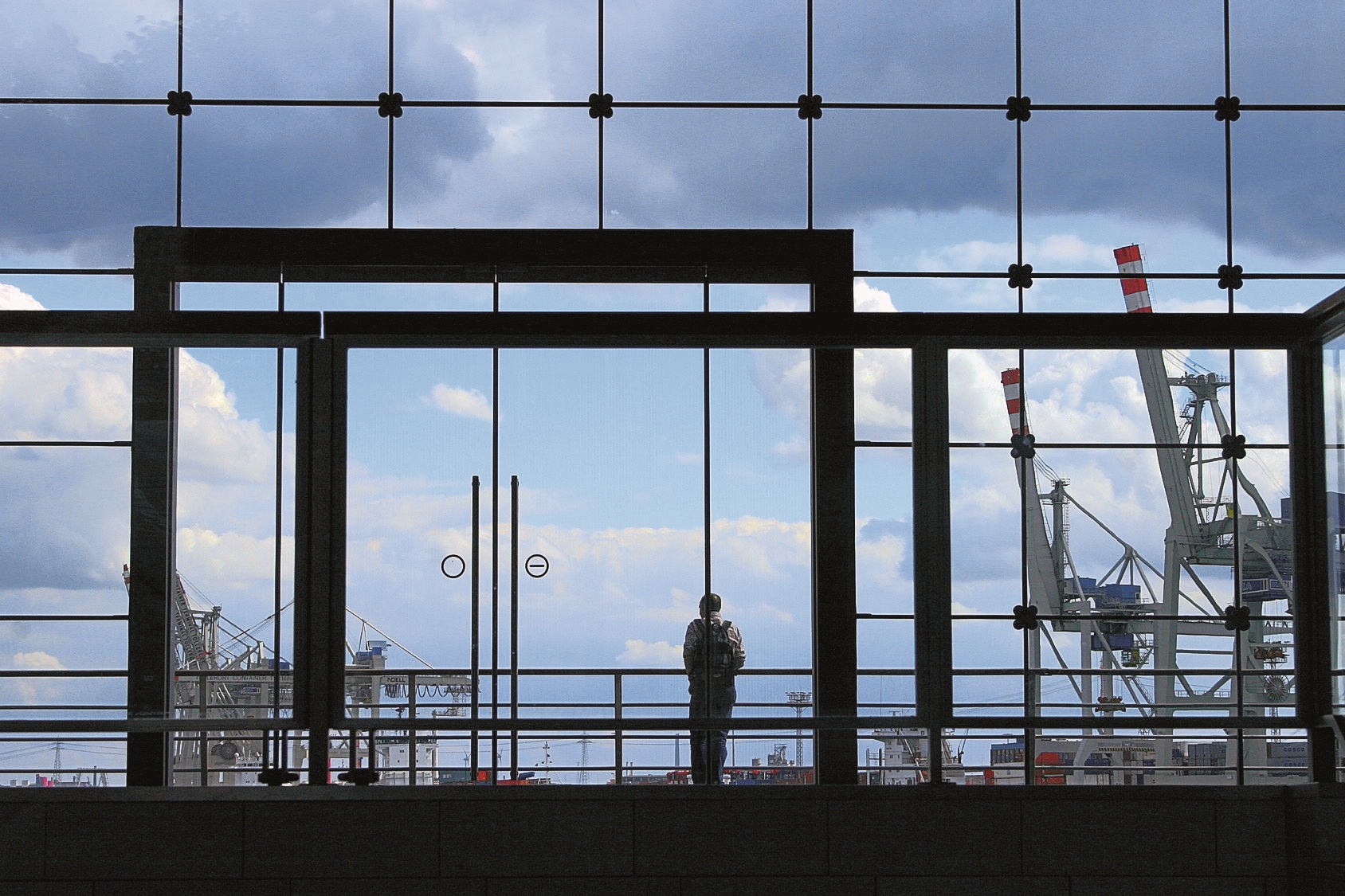 Group of transport ships waiting to carry oil, gas, petrochemicals for export, floating in sea at evening rain storm background aerial view from drone