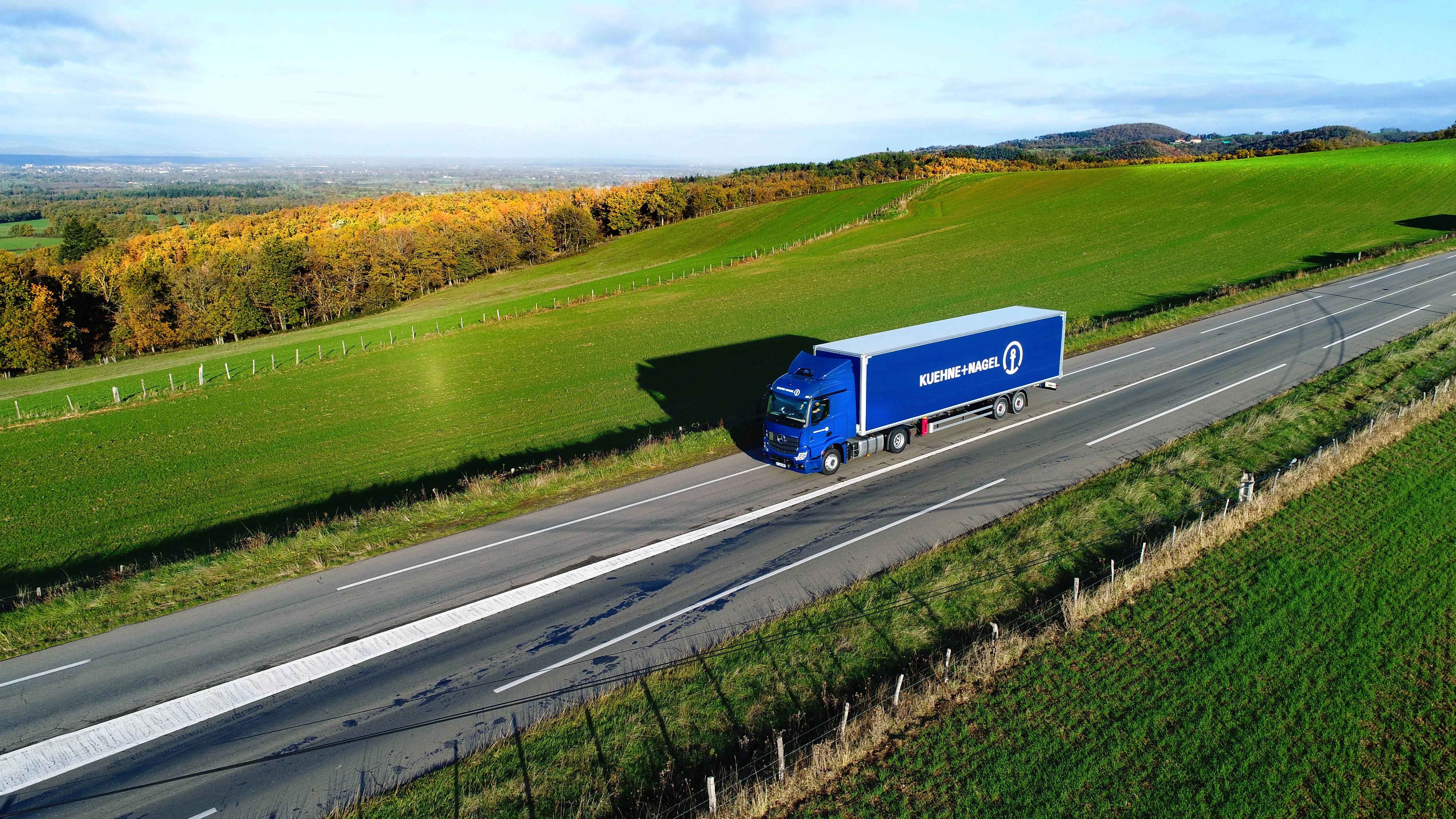 Blue Kuehne + Nagel truck on the road during the sunny day