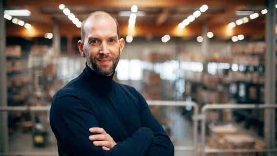 Christian standing in front of warehouse racks