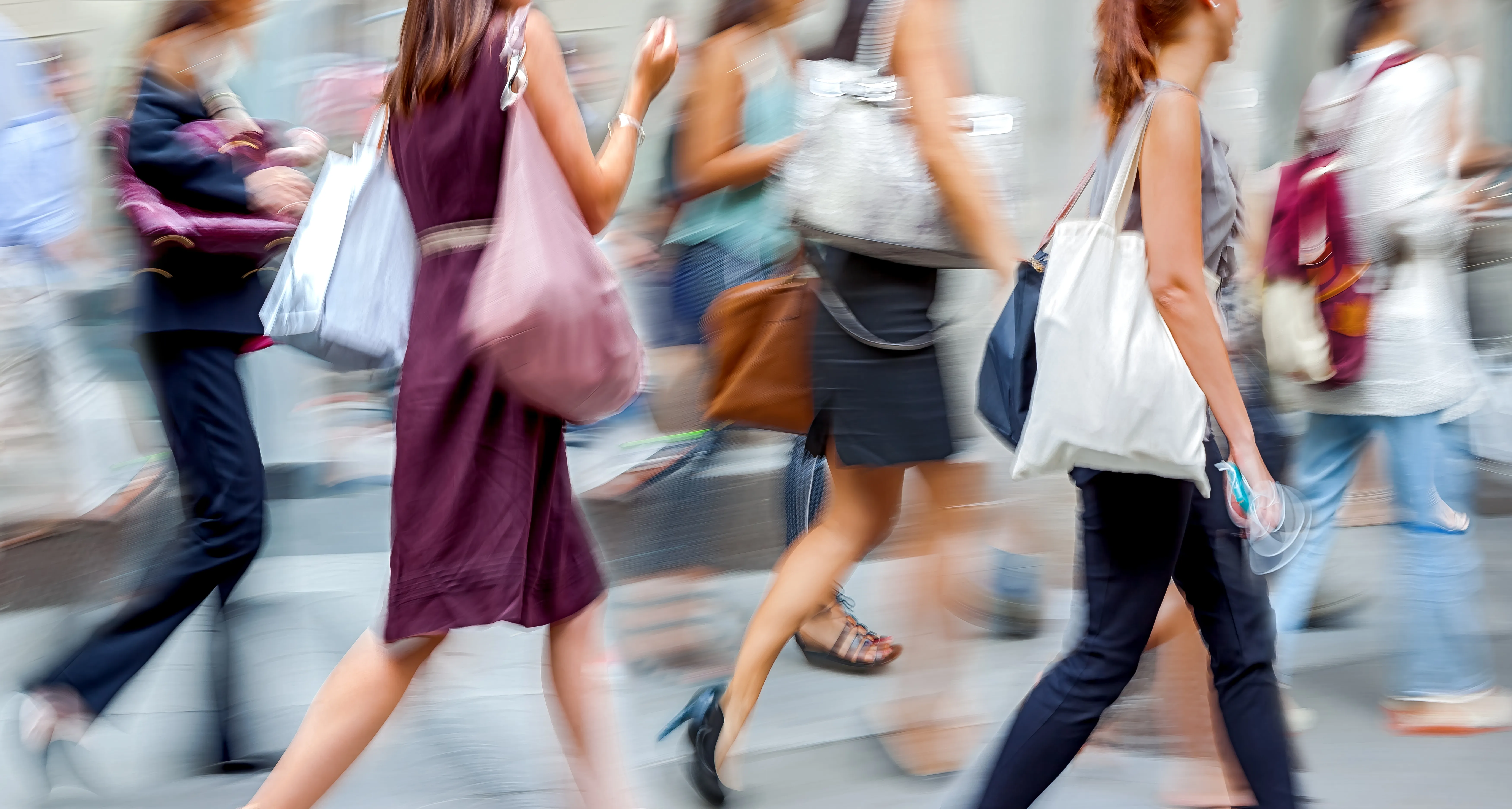 Women with shopping bags walking on a street on a busy day