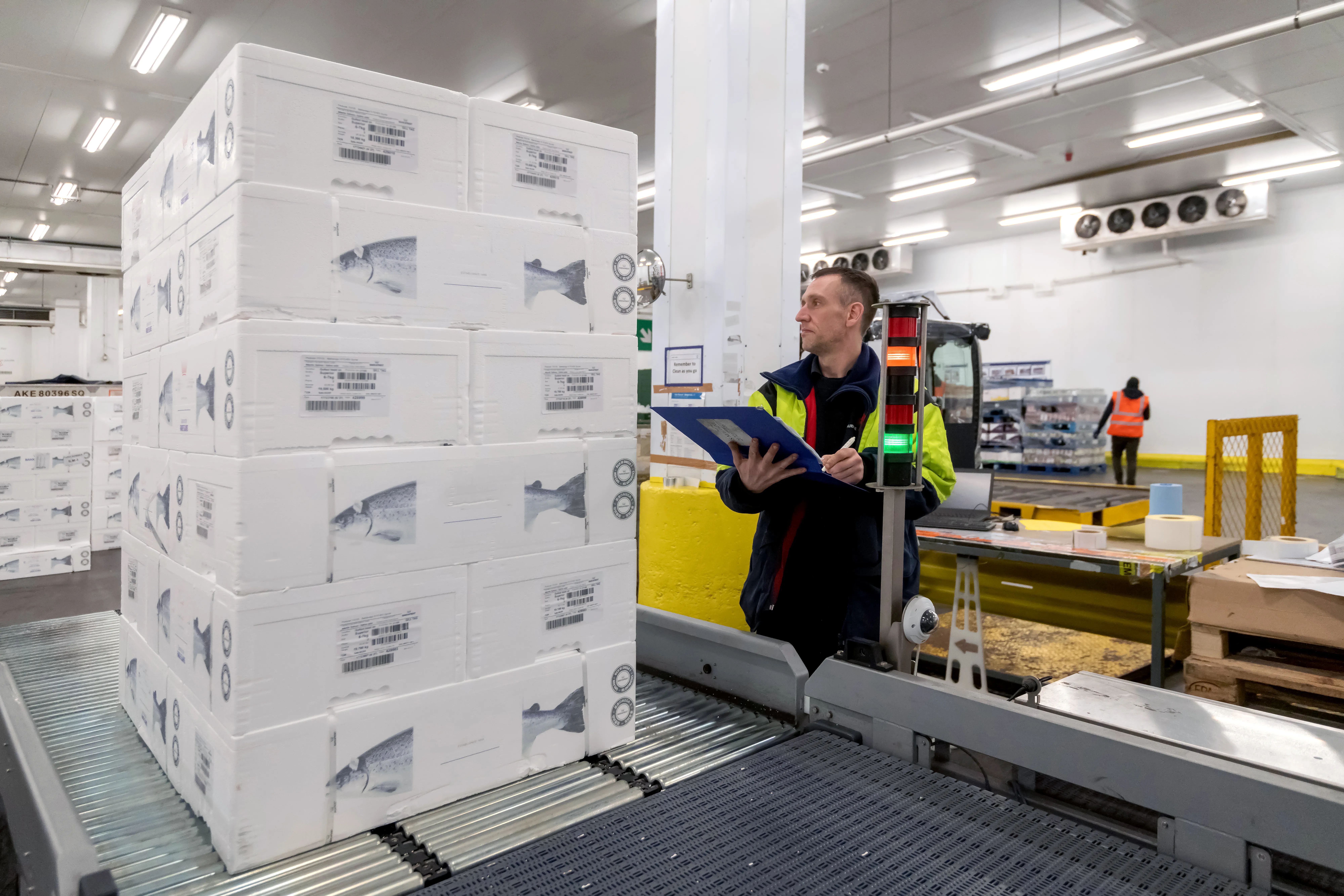 Employee checking the packages and writing on the board in warehouse