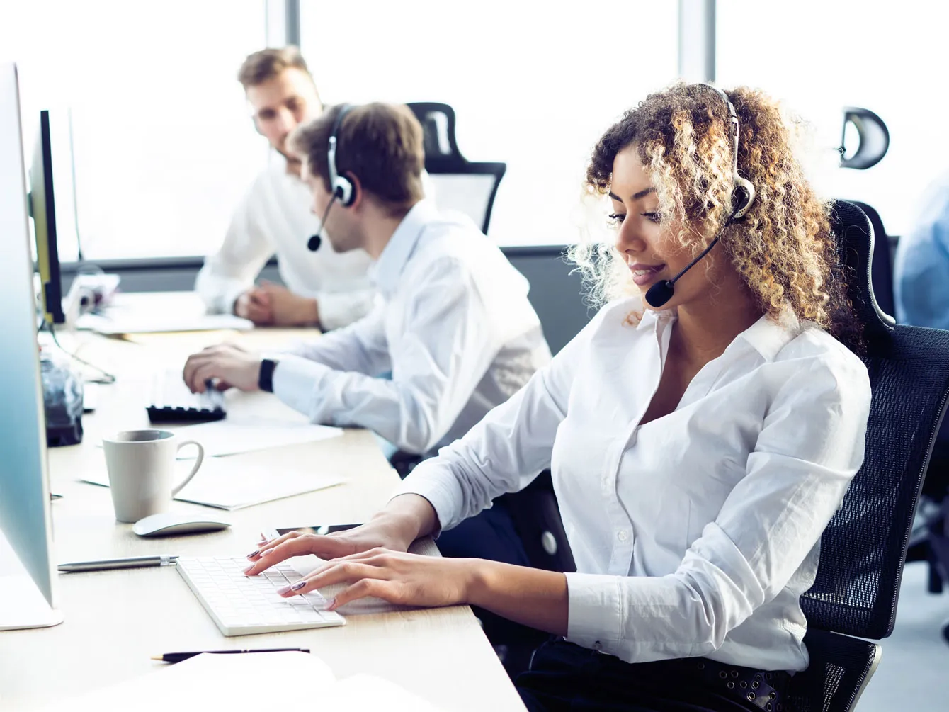 Women working in corporate speaking on headphones