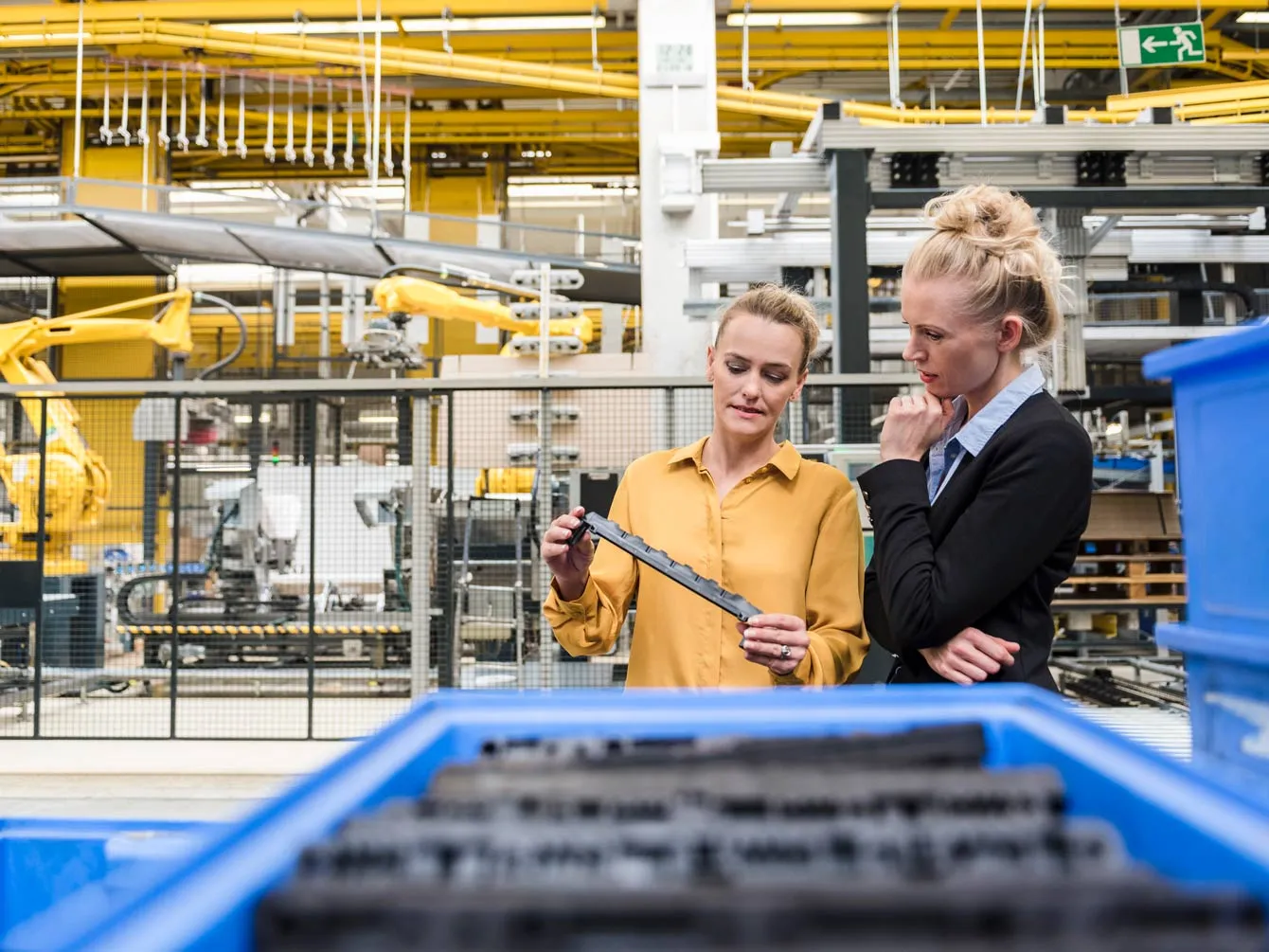 Worker and manager near a factory line, controlling the proccess