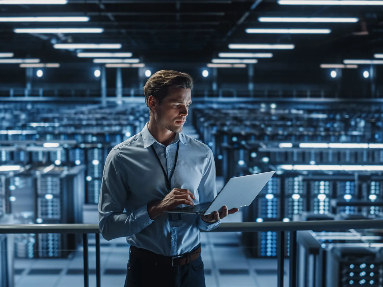 Man holding laptop in the big server room