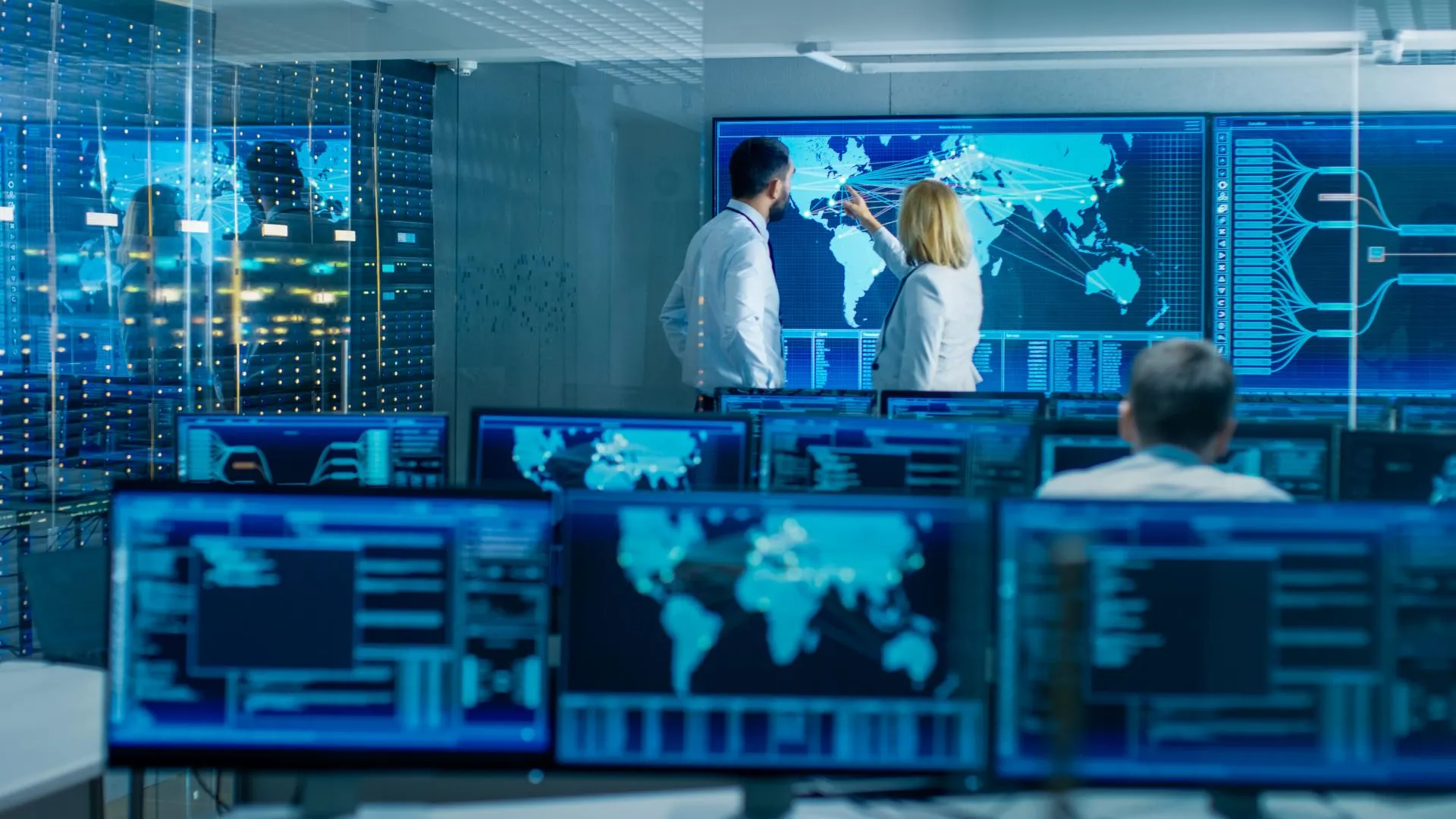 Scientists analyze global data on large computer screens in a high-tech control room