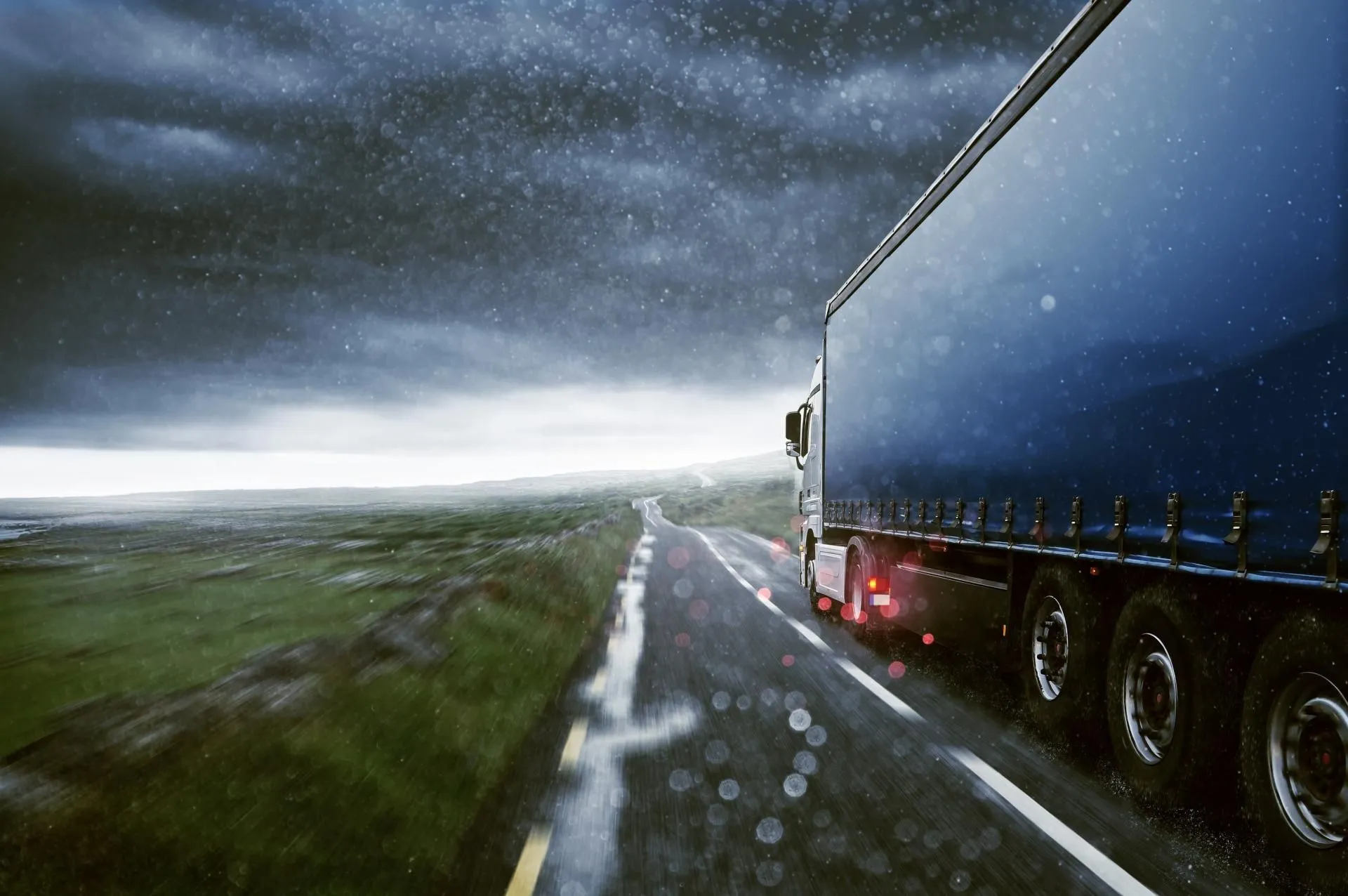 Blue cargo truck on rainy road
