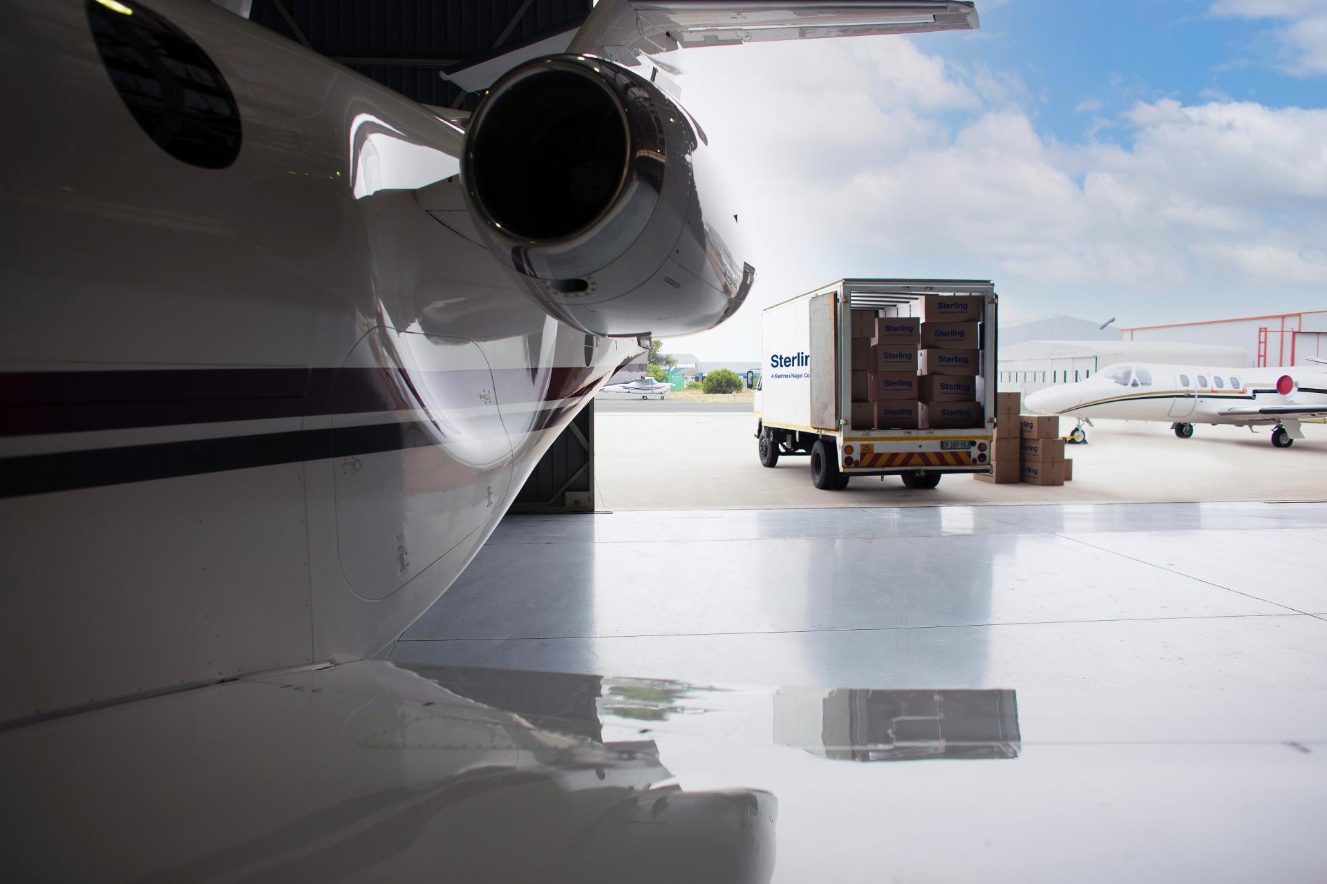 Company planes in hangar with a white Sterling truck parked, prepared to load cargo
