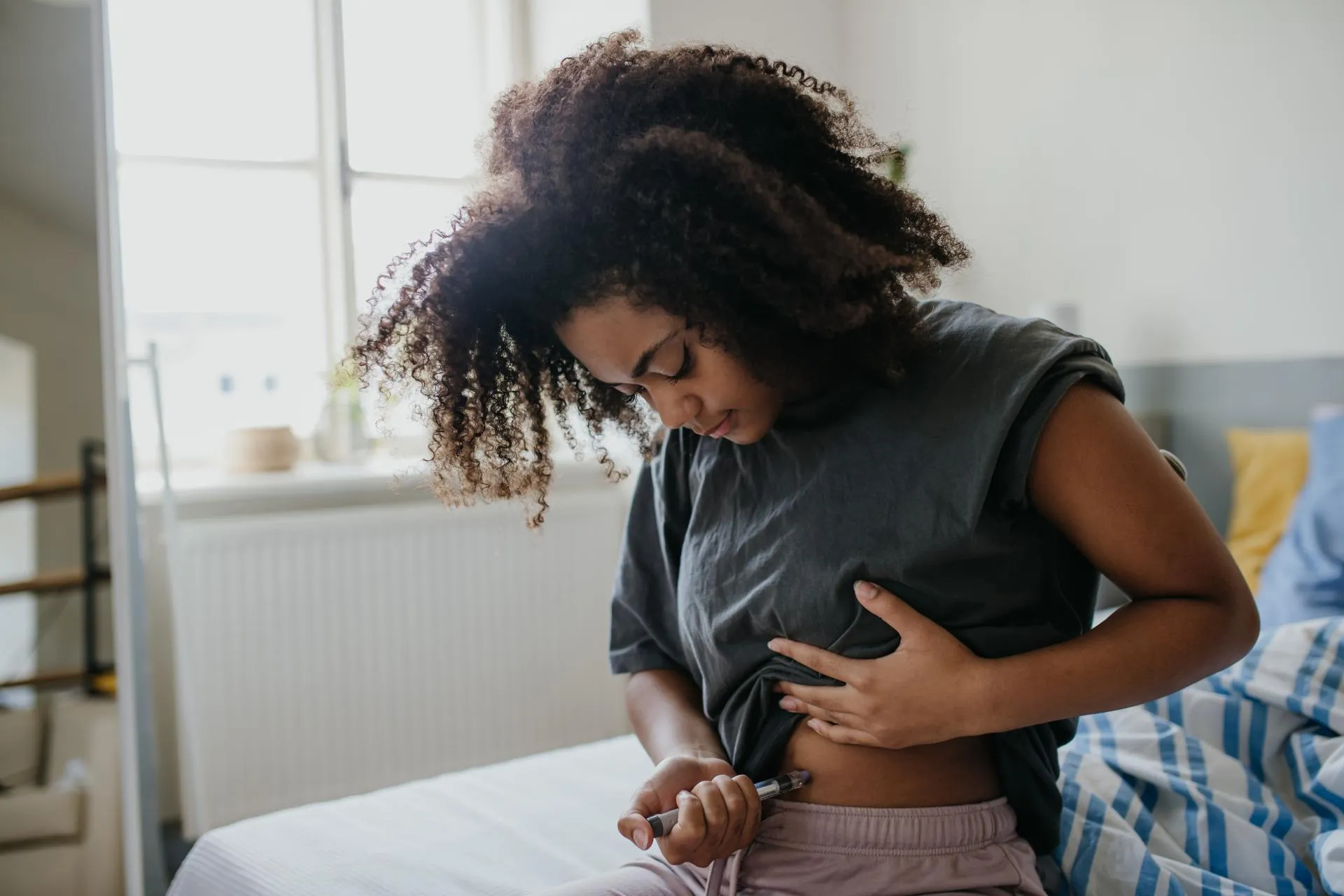 Teenage-girl-injecting-insulin-into-her-abdomen-in-the-morning-feelin-her-blood-sugar-is-high.jpg