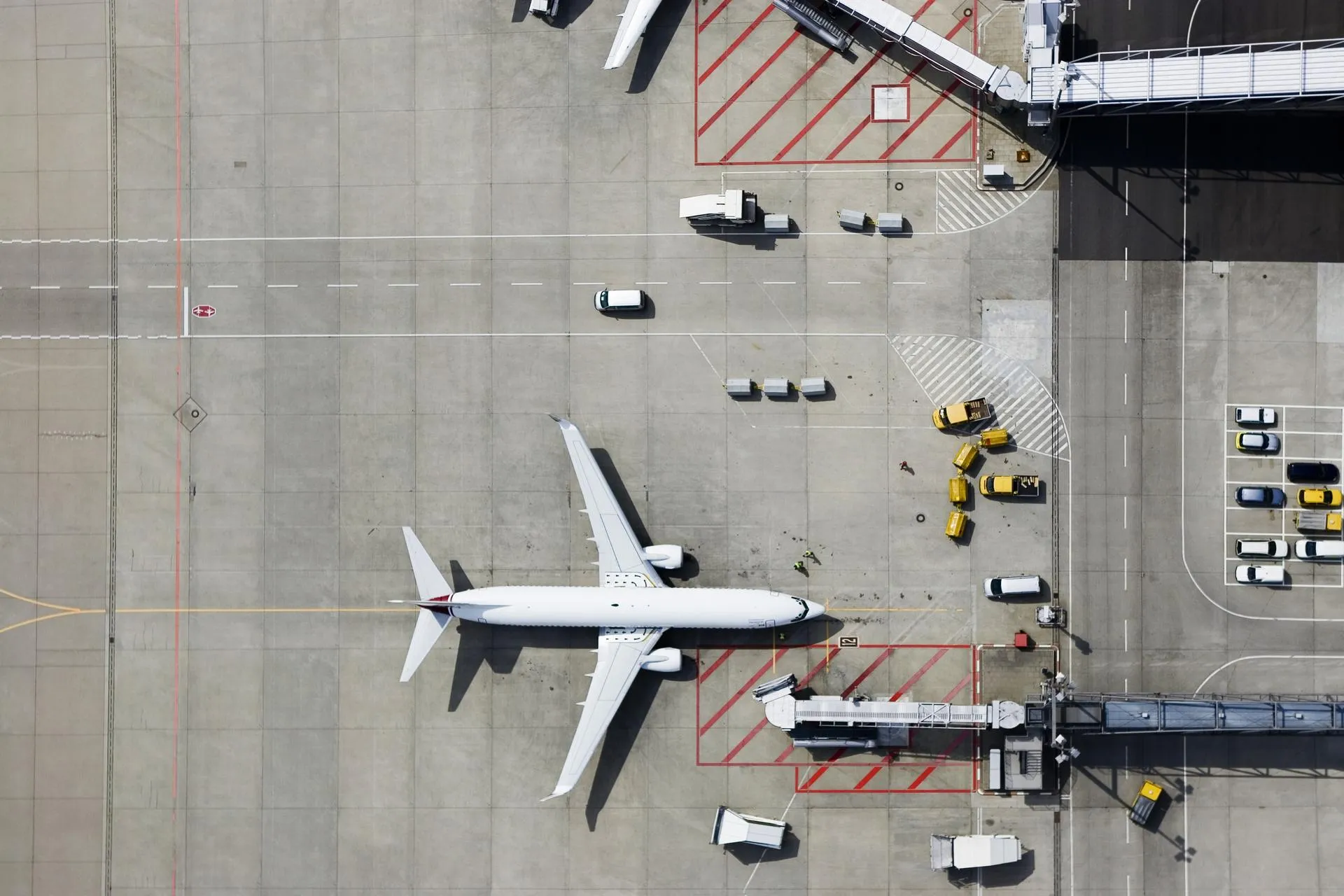 Airplane on runway surrounded by cars supplying it for take off