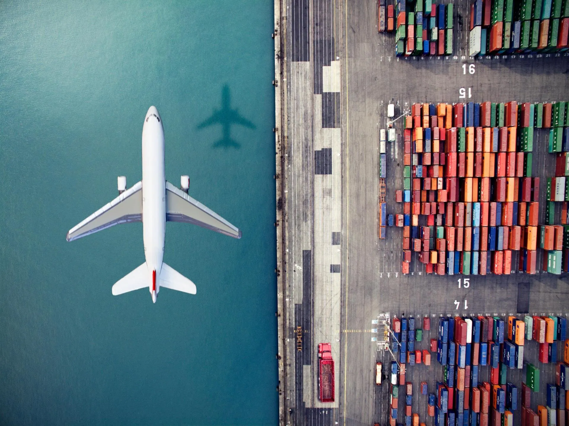 Airplane flying over container port