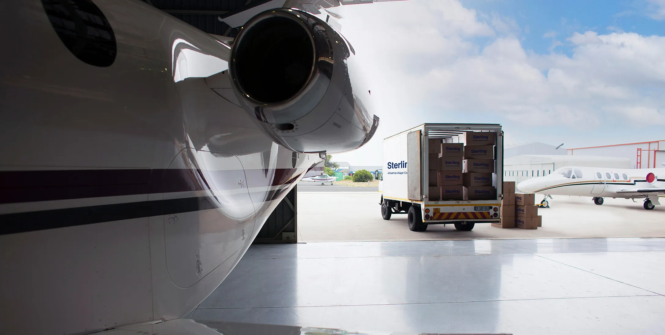 Truck delivering package to load into a plane in hangar