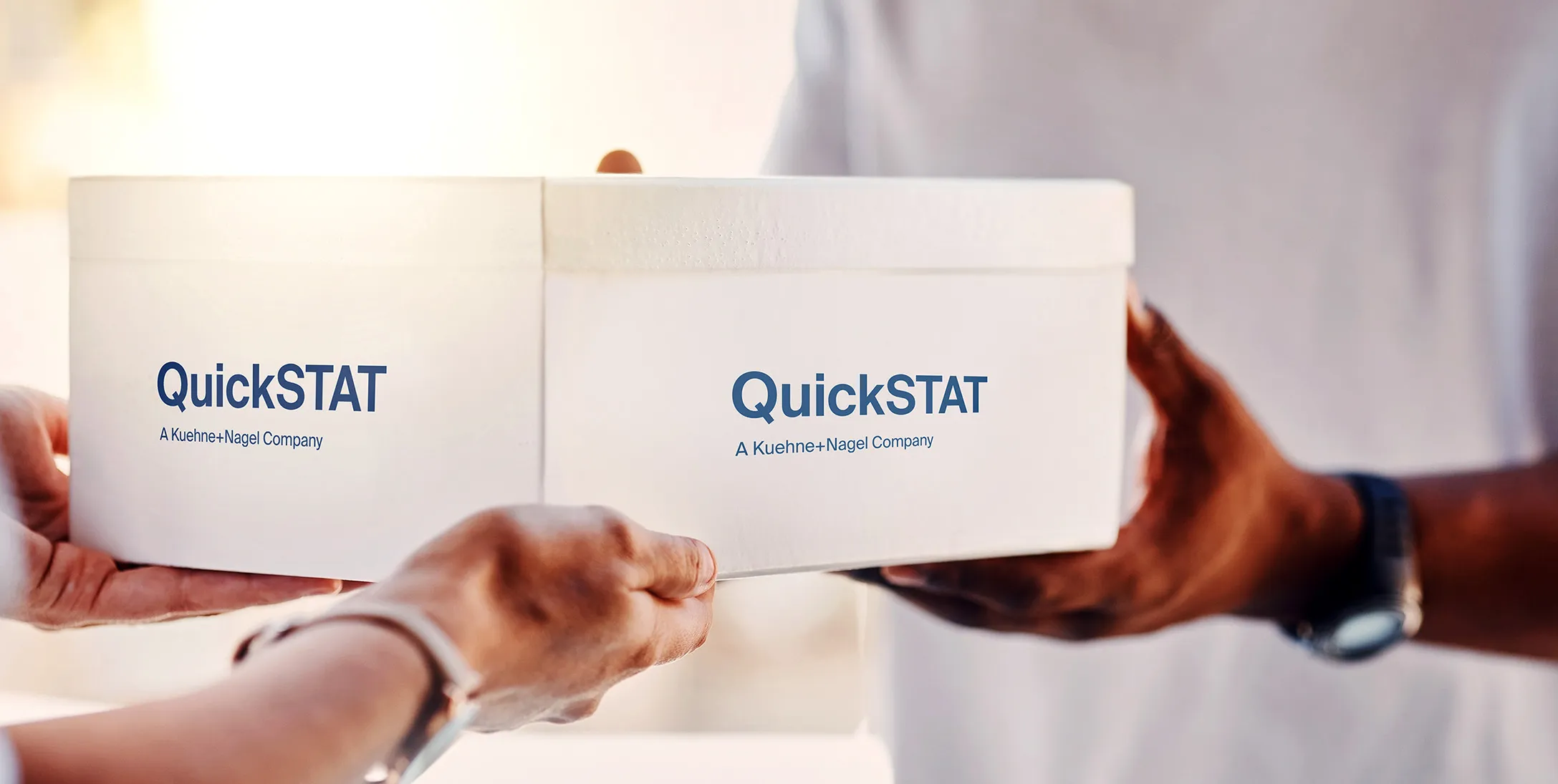 2 persons holding a white box with QuickSTAT written on it